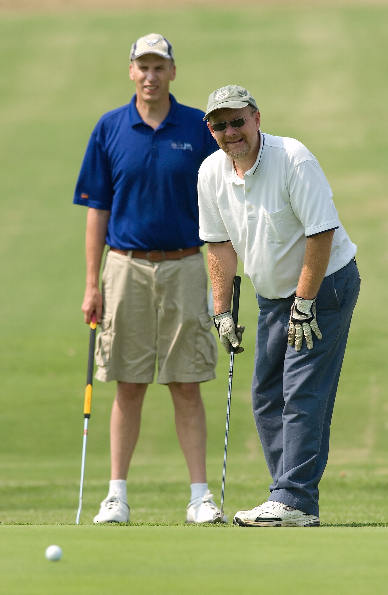 Tony Stevens (right), Stillwaters Presbyterian Church, stands by to see if his 30 foot putt goes in the hole at the Bluesuiters Golf Tournament on base Sept. 4. The annual event features community members and Dover Team members coming together for a day of fun and camaraderie. Pictured left is teammate Chaplain (Lt. Col.) John Groth, 512th Airlift Wing Chapel Office. Mr. Stevens made the putt. (U.S. Air Force photo/Jason Minto)