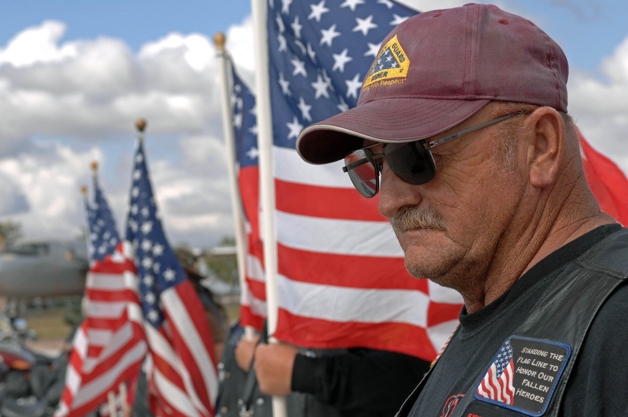 Ed Ruse, Patriot Guard rider, stands with other riders at the South Dakota Air and Space Museum during the 9/11 memorial Sept. 11. The Patriot Guard Riders stand the flag line to honor America's fallen heroes, veterans and present members who continue to serve. (U.S. Air Force photo by Airman Corey Hook)