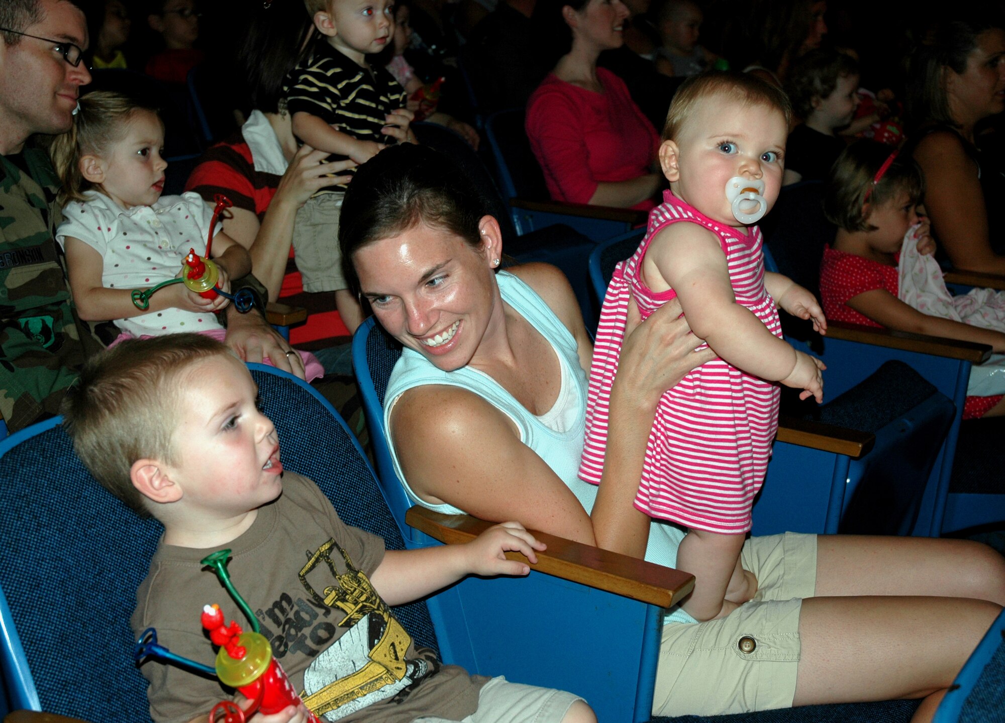 A family watches as the Sesame Street characters perform live at the base theater for more than 490 families as part of The Sesame Street Experience for Military Families tour Sept 11. Sesame Workshop and the United Service Organizations partnered to bring the free 25-min show to more than 40 military installations across the United States as part of Sesame?s military outreach program Talk, Listen, Connect. (U.S. Air Force photo/Capt. Carrie L. Kessler)