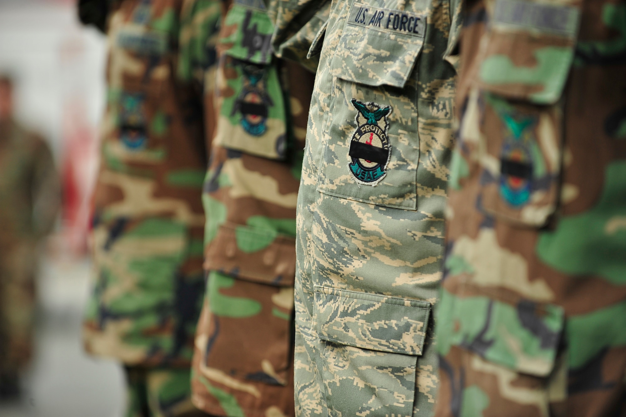 MOODY AIR FORCE BASE, Ga. -- Airmen of the 23rd Civil Engineer Squadron fire department wear pieces of black tape across their fire fighter's badge during a September 11 memorial ceremony here Sep. 11. The black tape is worn in honor of those who lost their lives during the September 11, 2001 terrorist attacks. (U.S. Air Force photo by Senior Airman Elizabeth Rissmiller)