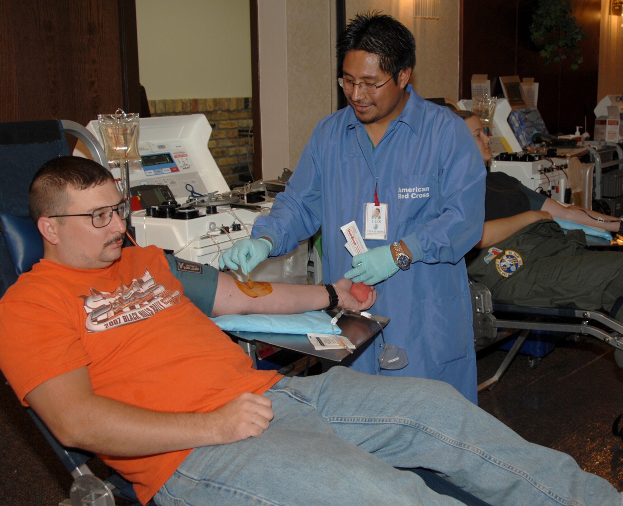 Offutt Air Force Base, Neb. -- Staff Sgt. Joel Pipkin, a technical controller with the 1st Airborne Command and Control Squadron, waits as Luis Marcos, an American Red Cross automated collection specialist, prepares him for a double red blood cell donation. The Red Cross hosted a blood drive at the Community Center here Sept. 11 and 12 as part of Patriot Day, in remembrance of the victims of Sept. 11, 2001. (U.S. Air Force Photo By/Kendra Williams) 