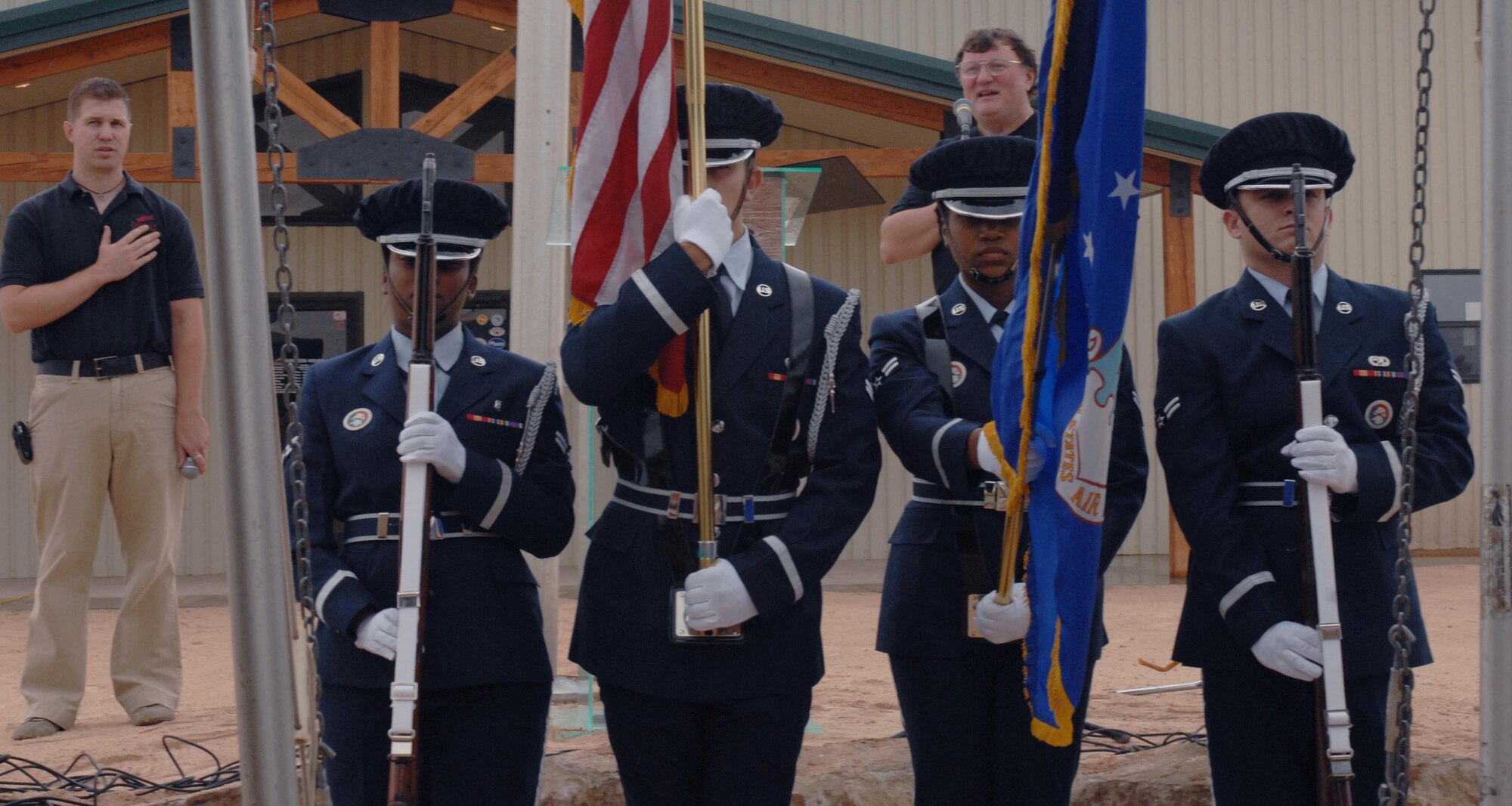 CANNON AIR FORCE BASE, N.M. - The base honor guard posts the colors during the national anthem, sung by Van Walworth, at Patriot Outdoors Sept. 11.  Base leadership and Airmen showed up to pay respect to the victims of the Sept. 11, 2001 attacks during a memorial service being held for the Clovis and base communities.  (U.S Air Force photo/Airman 1st Class James R. Bell)