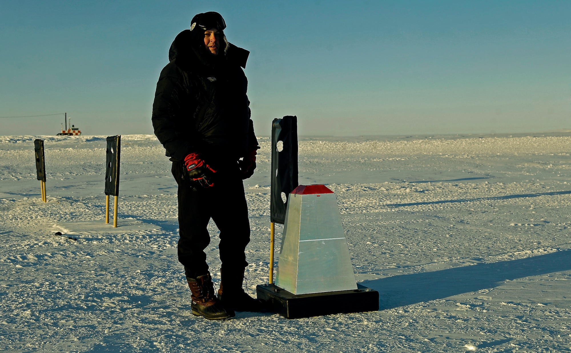 Maj. Corey A. Simmons stands next to a reflective cone on the Pegasus Ice Runway near McMurdo Station, Antarctica, on Sept. 10. Major Simmons was part of an aircrew that tested the concept of using night vision technology in combination with the reflective cones and limited electrical lighting to land safely on the ice runway after dark. The aircrew is part of Joint Task Force Support Forces Antarctica, headquartered at Hickam Air Force Base, Hawaii, and led by 13th Air Force. The joint task force is currently conducting Operation Deep Freeze in support of the National Science Foundation and U.S. Antarctic Program. Major Simmons is a C-17 evaluator pilot with the 62nd Operations Support Squadron at McChord AFB, Wash. (U.S. Air Force photo/Master Sgt. Chris Vadnais)