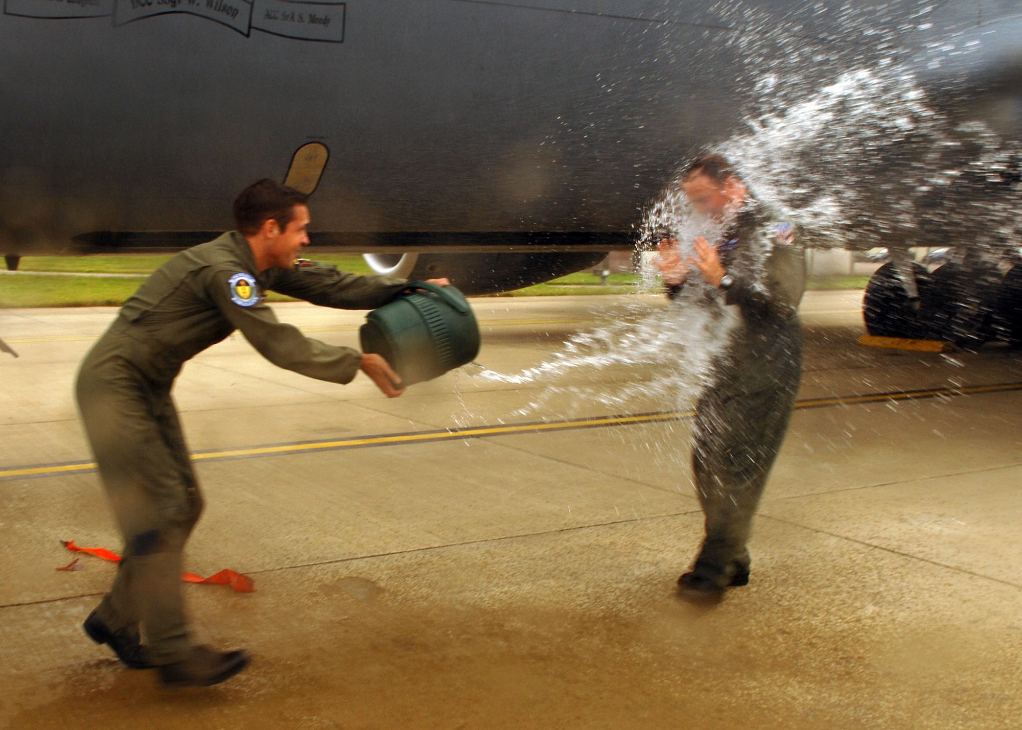 First Lt. Peter Shayhorn, 351st Air Refueling Squadron, throws a bucket of water over Tech. Sgt. RaileR Cantrell, as he gets off a KC-135 Stratotanker after completing 6,000 flying hours Aug. 18. (U.S. Air Force photo by Staff Sgt. Tyrona Pearsall)