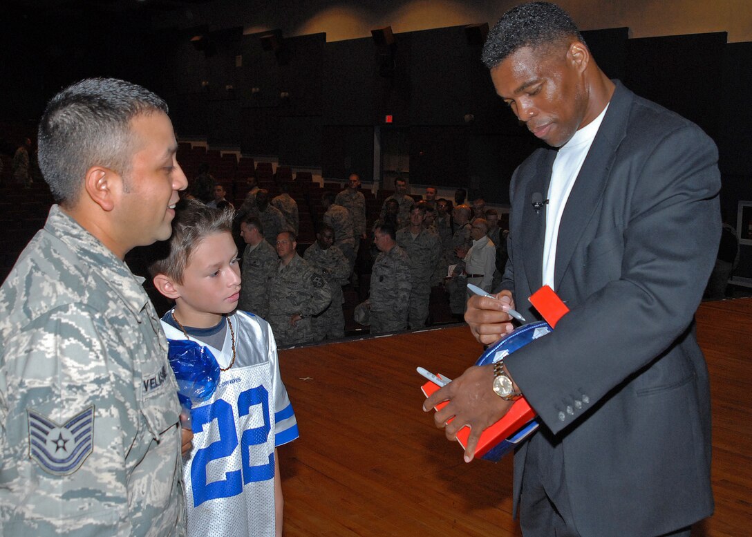 Herschel Walker, 1982 Heisman Trophy winner and former Dallas Cowboy running back, autographs books and footballs for Sheppard members after sharing his experiences suffering from dissociated identity disorder Sept. 11. (U.S. Air Force photo/Lou Anne Sledge)