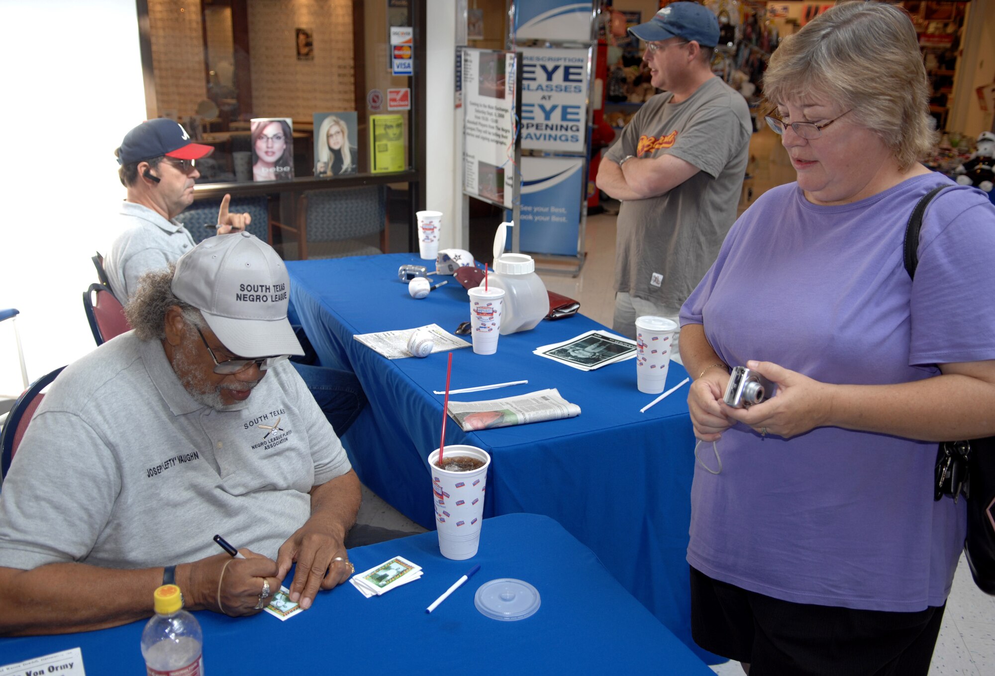 Joseph "Lefty" Vaughn (front) and Dick "Lefty" O’Neal autograph cards, baseballs and other memorabilia for fans at the base exchange. Mr. Vaughn and Mr. O’Neal are both former Negro League baseball players. Additionally, Mr. O’Neal is a retired Air Force major. (U.S. Air Force photo by Staff Sgt. John Barton)