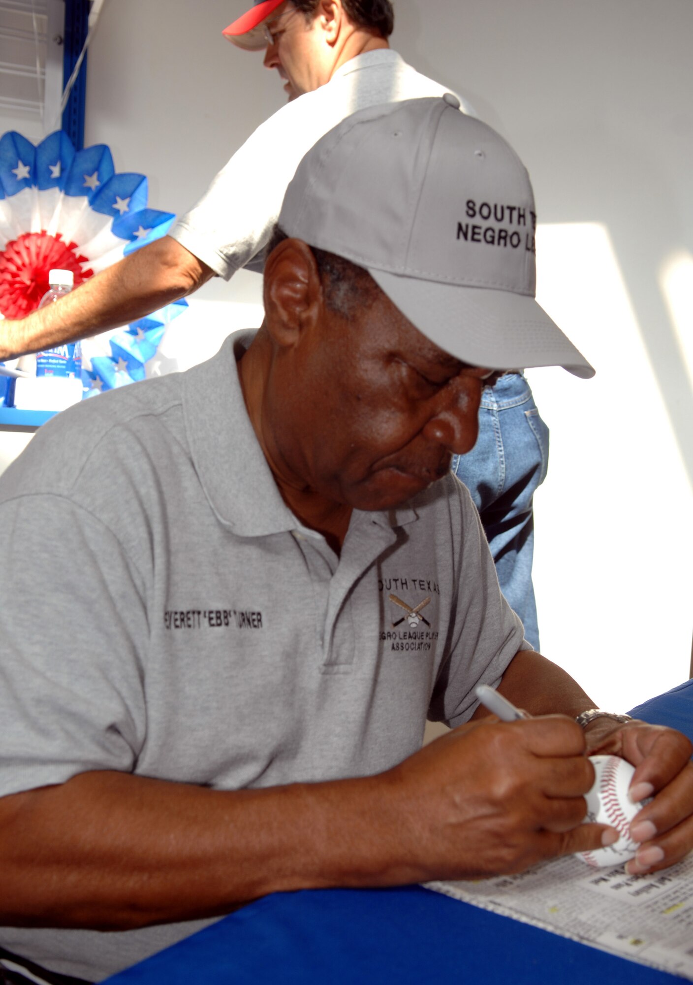 Everett Turner, a former Negro League baseball player and retired Air Force member, autographs baseballs Sept. 6 at the Goodfellow Base Exchange. (U.S. Air Force photo by Staff Sgt. John Barton)