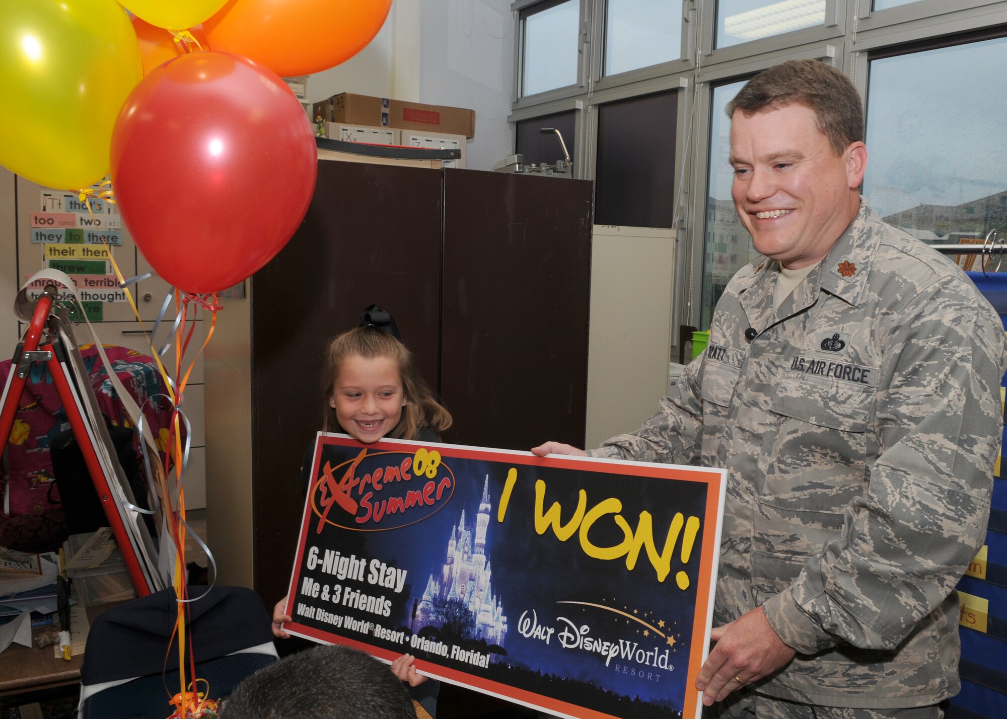 SPANGDAHLEM AIR BASE, Germany -- Maj. Michael Wyatt, 52nd Force Support Squadron commander, presents Kelsey Garcia with an all-expense six night trip to Disney World for four that she won by participating in Extreme Summer. Kelsey is one of the youth category grand prize winners. (U.S. Air Force photo by Staff Sgt. Heather M. Norris)