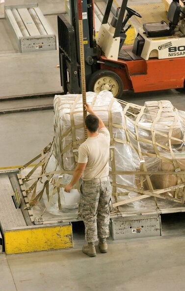 080820-F-4800M-175 -- DOVER AIR FORCE BASE, Del. – Airman 1st Class Brandon Rohde, 436 Aerial Port Squadron, measures the height of a pallet before it is processed and loaded onto an aircraft. The 436th APS's primary mission is to provide airlift support for the movement of cargo, mail and passengers to support the operations directed by the President, DoD or the Joint Chiefs of Staff, as well as providing airlift support of worldwide humanitarian efforts, exercises, contingencies and emergencies.  (U.S. Air Force photo/Jason Minto)