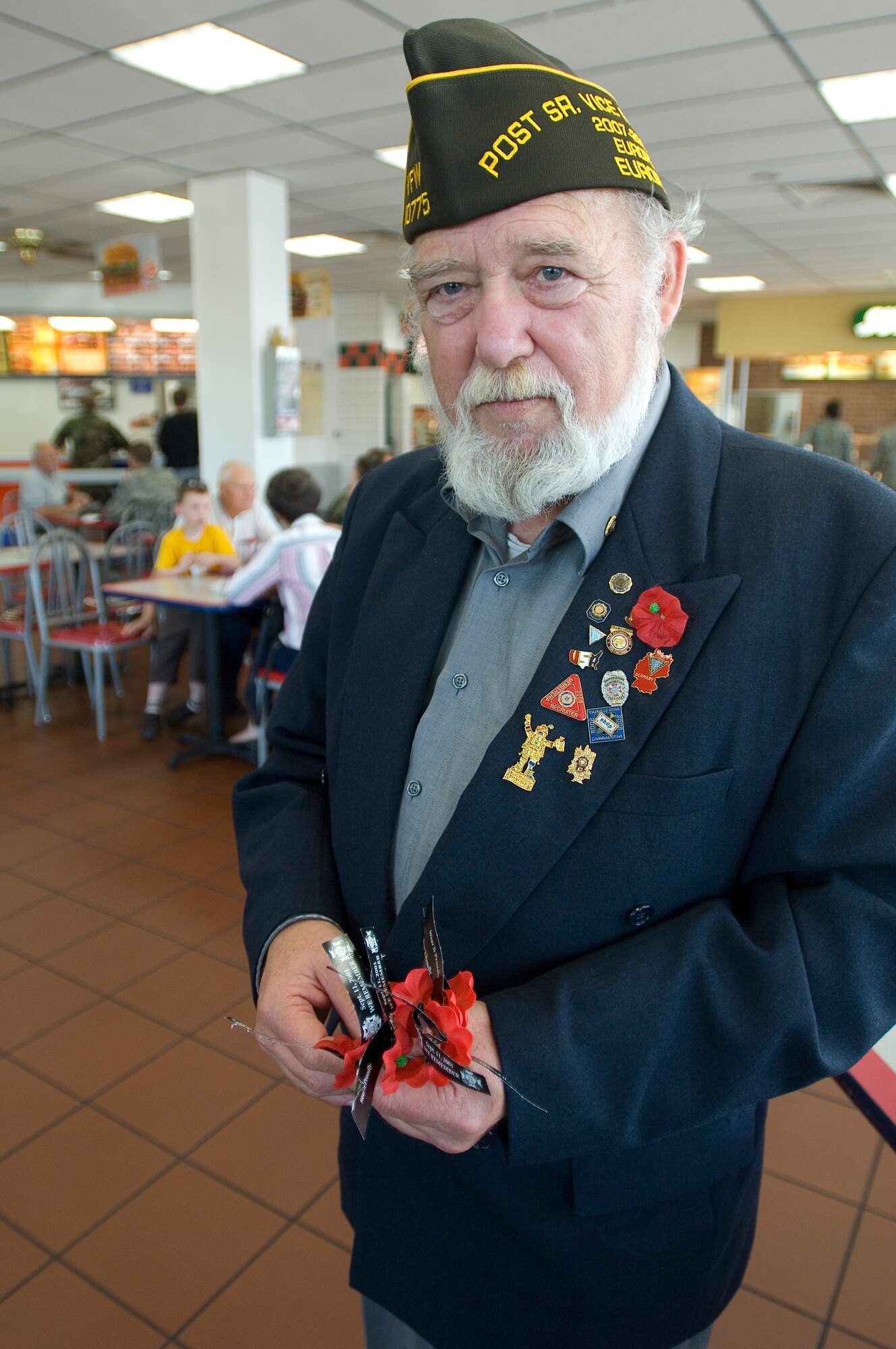 SPANGDAHLEM AIR BASE, Germany -- Master Sgt. (Ret.) Larry Barnwell, senior vice commander of Veterans of Foreign Wars Post 10775 Ronnie A. Wright, hands out flowers to Spangdahlem Sabers and their families in remembrance of the 9/11 terrorist attacks. (U.S. Air Force photo by Airman 1st Class Nathanael Callon)