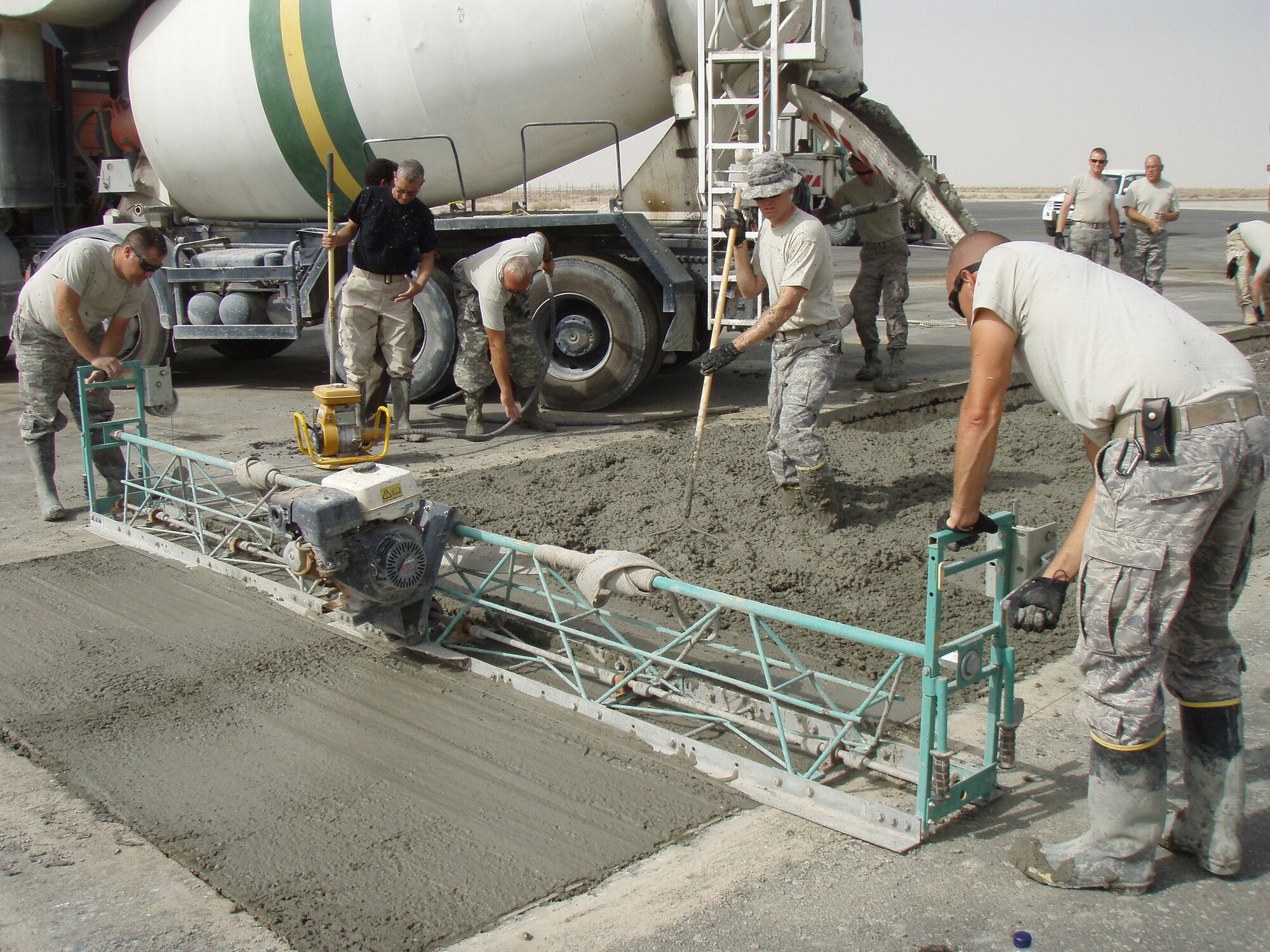 SOUTHWEST ASIA -- Members of the 386th Expeditionary Civil Engineer Squadronlay down concrete during the consruction of a concrete maintenance pad in August at an air base in Southwest Asia. The concrete pad, set to open Sept. 15, will be used a a maintenance area for aircraft mechancis at the 386th Air Expeditionary Wing. More concrete pads are expected to be constructed in the future. (U.S. Air Force cortesy photo) 