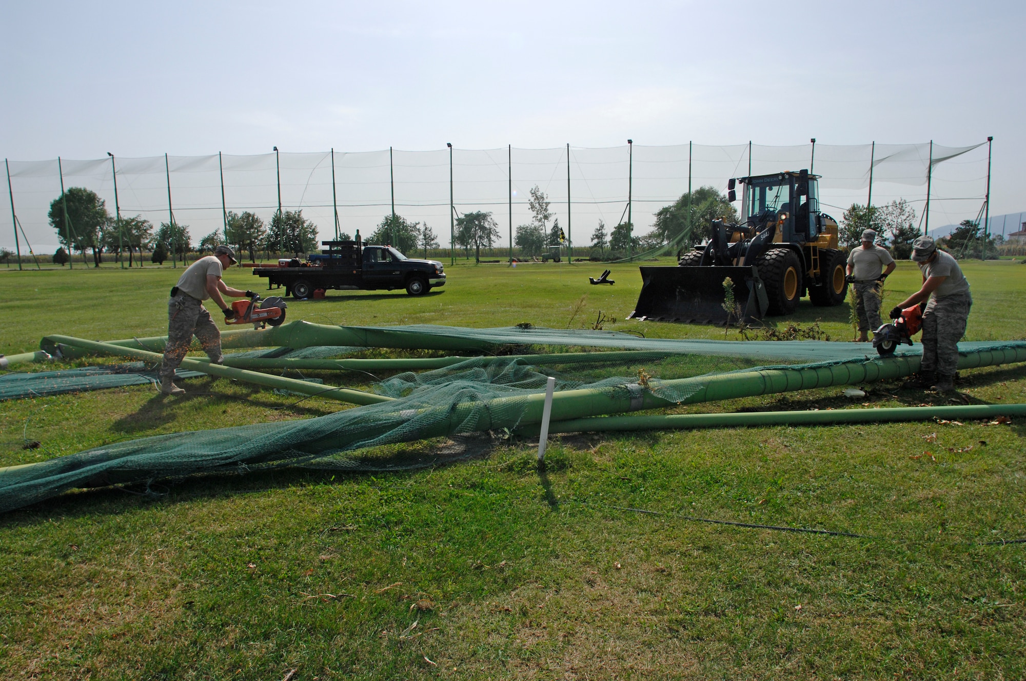 Airmen from the 31st Civil Engineer Squadron slice through metal posts at the driving range Sept. 10. A thunderstorm ripped through Aviano with winds up to 90 mph Sept. 7. The storm caused more than half a million dollars in damage to the base. (U.S. Air Force photo/Airman 1st Class Ashley Wood)