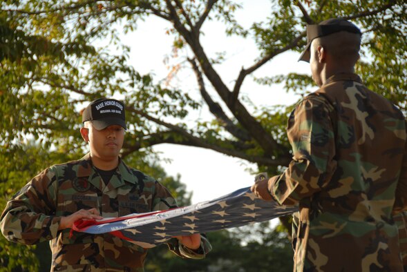 MISAWA AIR BASE, Japan -- Staff Sgt. Kenneth Escobar, 35th Force Support Squadron, performs the flag folding ceremony with a fellow honor guard member during a retreat ceremony Sept. 11, 2008.  The ceremony was held in remembrance of the 9/11 attacks.  (U.S. Air Force photo by Senior Airman Laura R. McFarlane) 