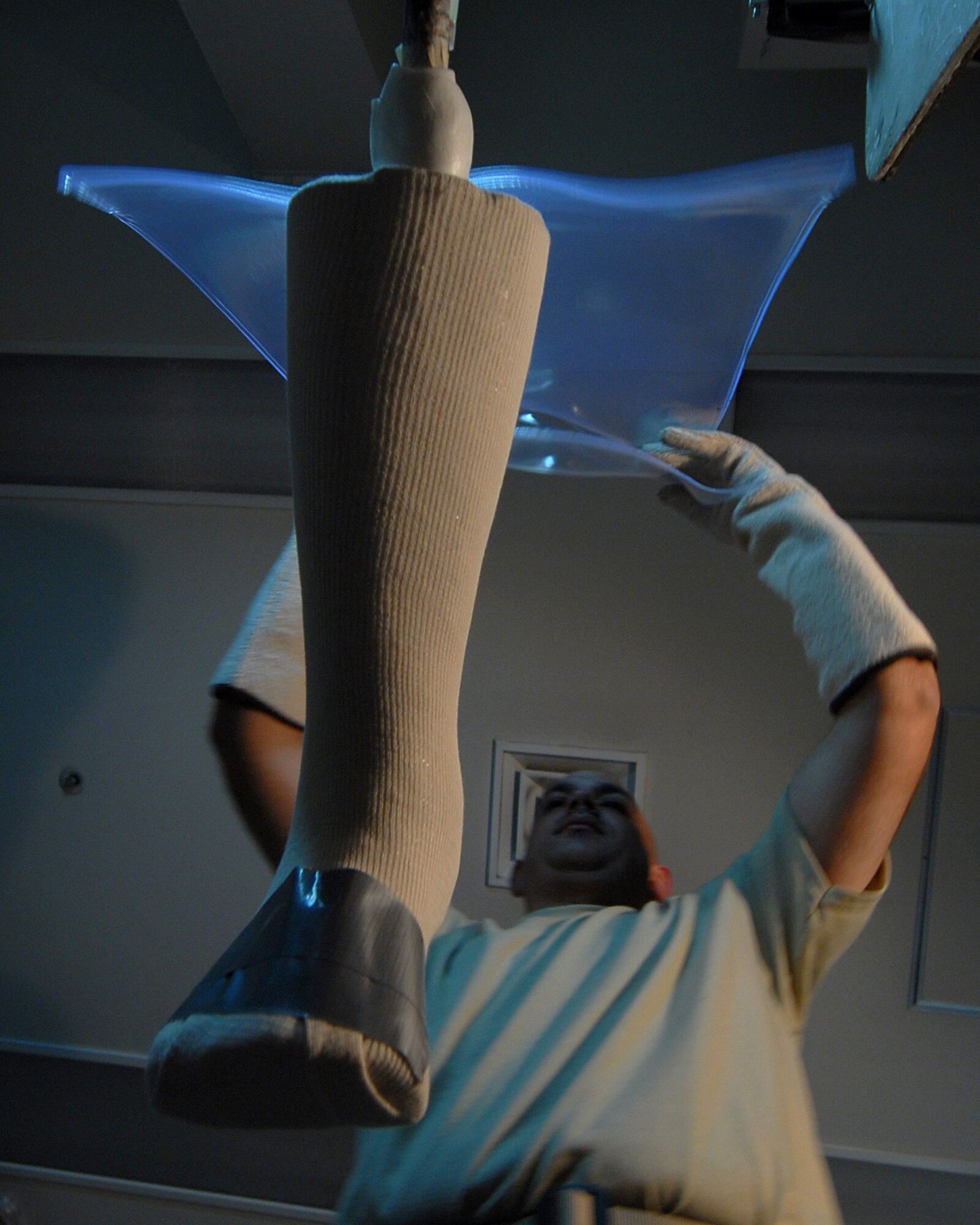 YOKOTA AIR BASE, Japan -- Technical Sergeant Sean McClintock places heated plastic on a cast molding, in the Orthotic Lab, on 10 Septeber. This just one step in the process of creating a brace that he makes for his patients. (U.S. Air Force photo by Senior Airman Laszlo Babocsi)(Released)