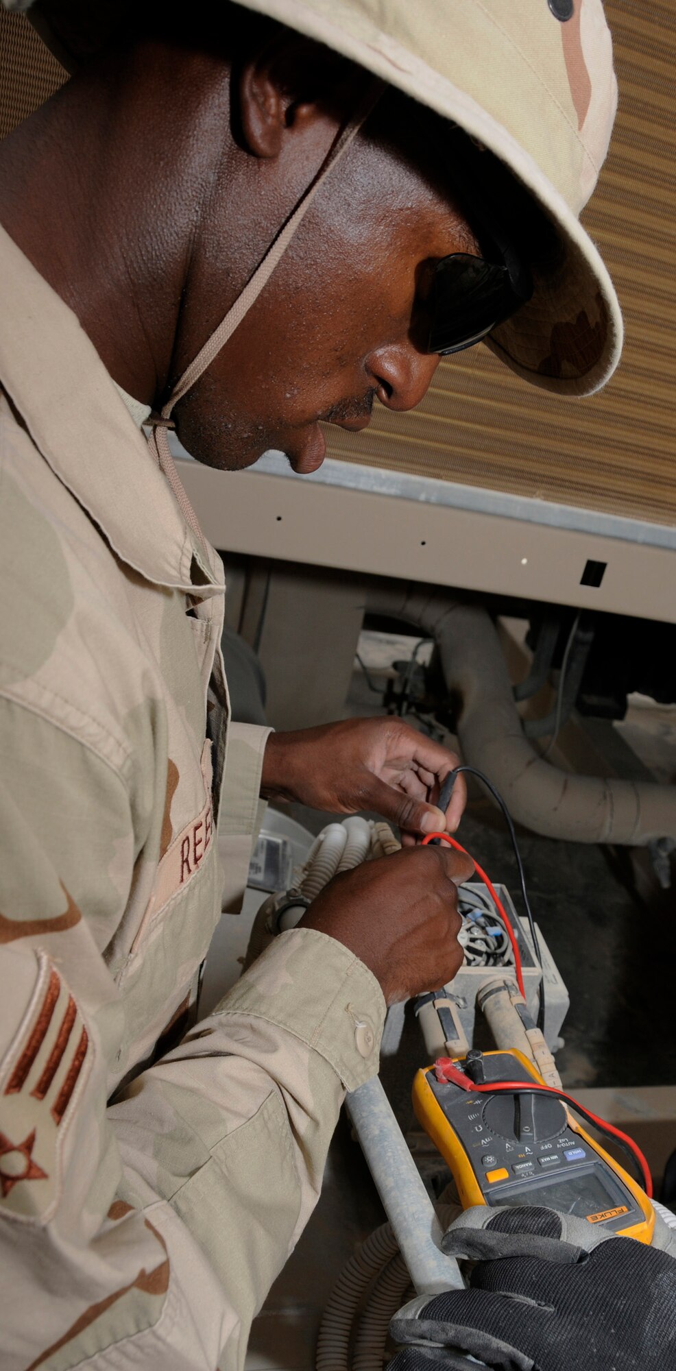 Senior Airman Lamar Reece, 379th Expeditionary Civil Engineer Squadron, checks current through a chill water valve to test power on an air conditioning unit Sept. 11, 2008.  Airman Reece is trying to restore power to the chiller at the Base Exchange in the Blatchford-Preston Complex.  The Heating Ventilation and Air Conditioning shop is in charge of maintenance of all air conditioning units at this undisclosed air base in Southwest Asia.  Airman Reece is deployed from Pope Air Force, N.C., supporting Operations Iraqi and Enduring Freedom and Joint Task Force-Horn of Africa.  (U.S. Air Force photo by Tech. Sgt. Michael Boquette/Released)