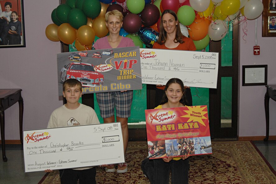 Marcela Cibo, Carol Neuman, Christopher Brooks and Kati Kaya pose with their prizes from the August Extreme Summer drawing, Sept. 5. Extreme Summer is an online competition hosted by United States Air Forces in Europe Services. Base members enter points online that were earned by participating in services activities and events for a chance to win prizes. (U.S. Air Force photo by Senior Airman Benjamin Wilson)