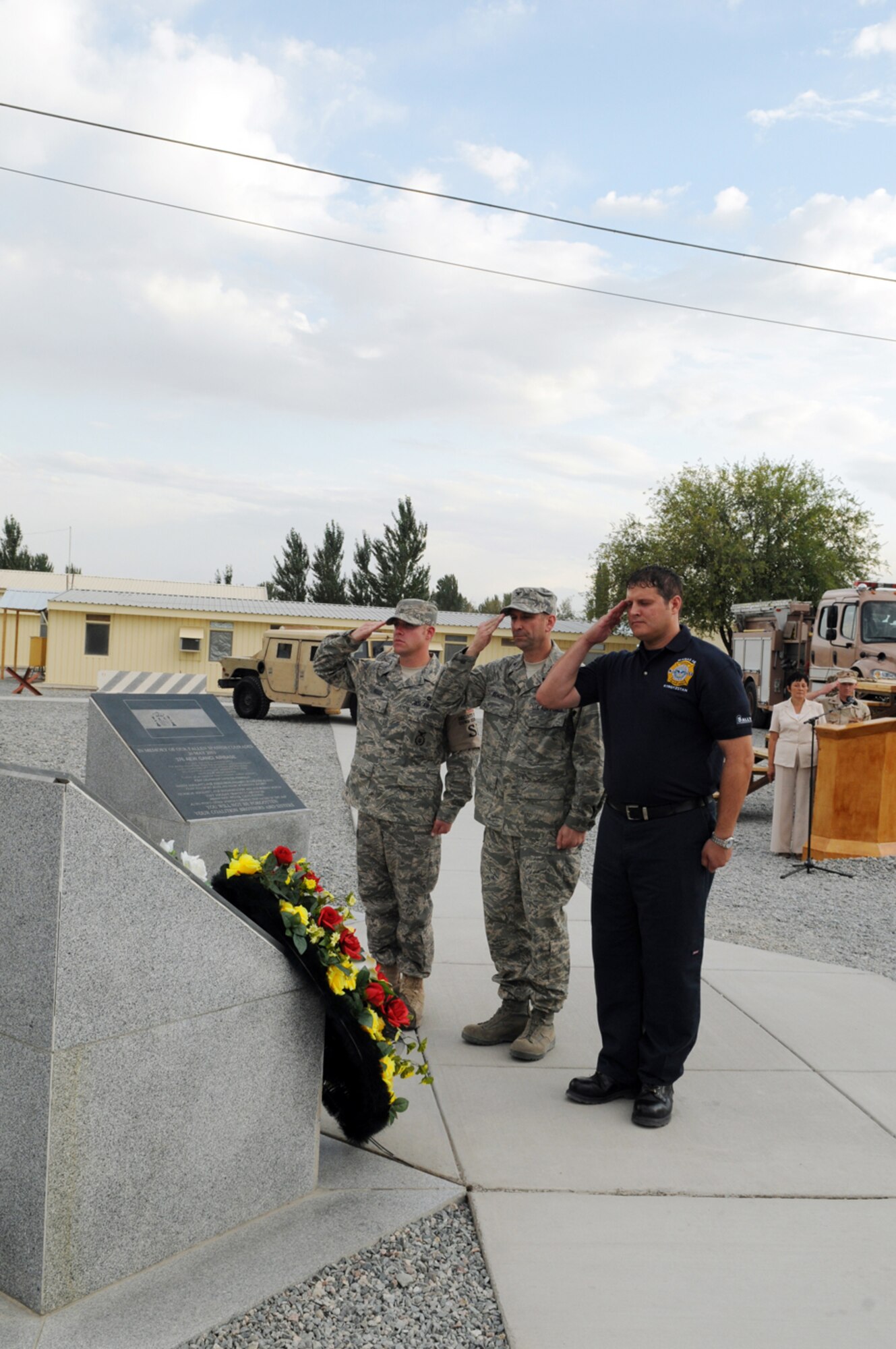 MANAS AIR BASE, KYRGYZ REPUBLIC -- Senior Airman Kevin Keller and Mr. George Parker join Col. Christopher Bence, 376th Air Expeditionary Wing commander, in rendering a salute at the Peter Ganci Jr. memorial during the Sept. 11 remembrance ceremony here. Dignitaries and representatives from ten nations joined more than 200 coalition servicemembers to pay tribute to the tragic events of 9/11 and the sacrifices made in the Global War on Terrorism since. (Air Force photo / Senior Airman Ruth Holcomb)  