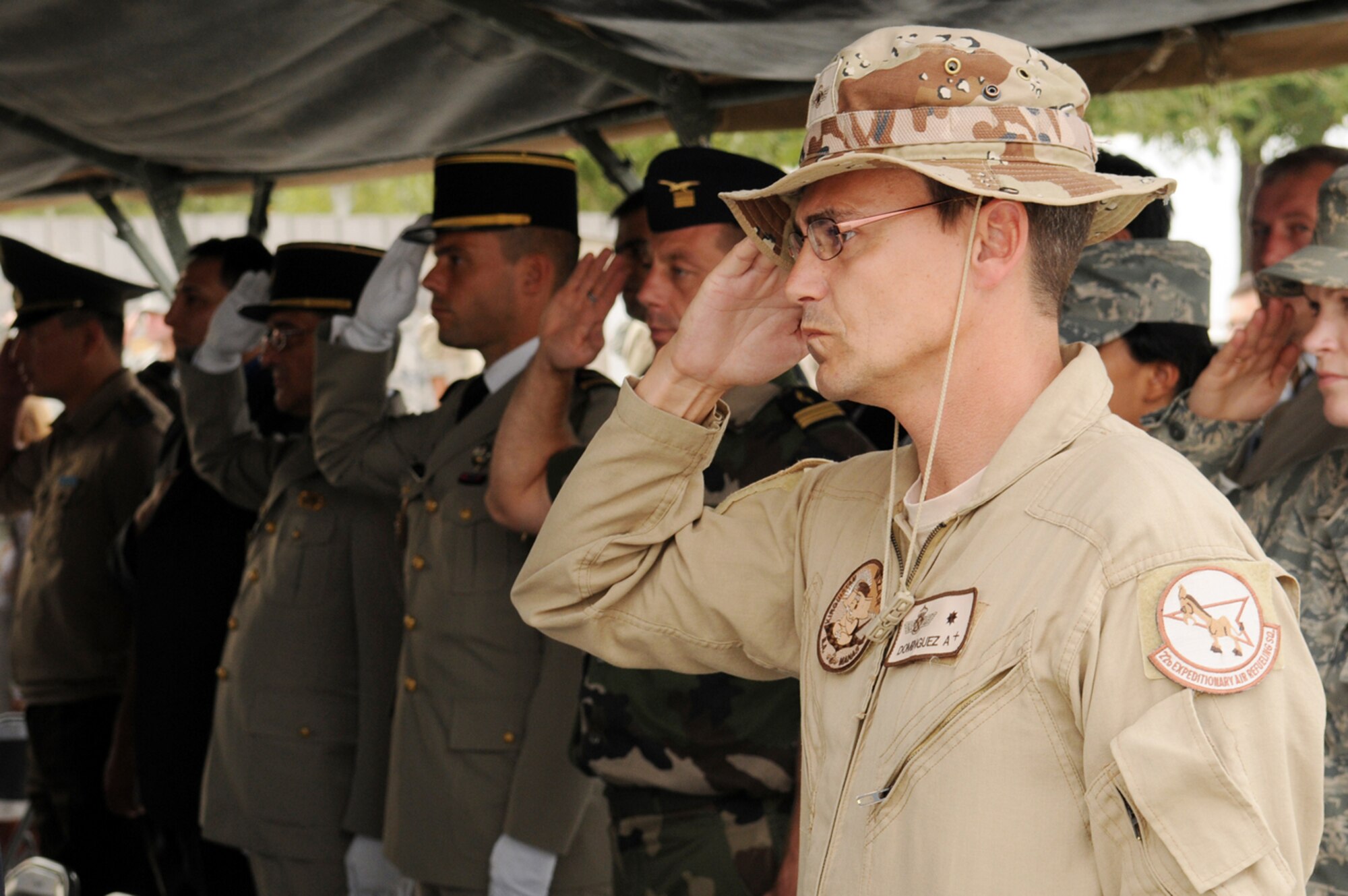 MANAS AIR BASE, KYRGYZ REPUBLIC -- Maj. Juan Dominguez, commander of the Spanish Air Force's "Mizar" Detachment here, salutes with coalition servicemembers and dignitaries from France, the Kyrgyz Republic and the United States as taps is played during the Sept. 11 remembrance ceremony. Dignitaries and representatives from ten nations joined more than 200 coalition servicemembers in remembering the tragic events of 9/11 and the sacrifices made in the Global War on Terrorism since. (Air Force photo / Senior Airman Ruth Holcomb)  