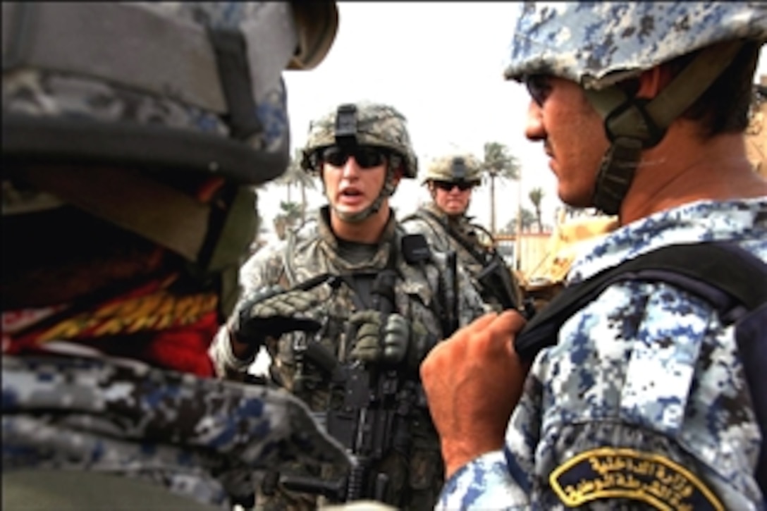 U.S. Army 1st Lt. Brandon Trauma talks to Iraqi National Policemen at a fueling station outside Forward Operating Base Loyalty in Beladiyat, eastern Baghdad, Iraq, Sept. 8, 2008. The soldiers are assigned to Charlie Company, 2nd Battalion, 30th Infantry Regiment, 4th Brigade Combat Team, 10th Mountain Division.