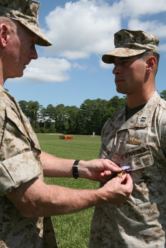 Maj. Gen. Richard T. Tryon (left), Commanding General, 2nd Marine Division, awards the Silver Star Medal to Capt. John Roussos (right), former platoon commander for Bravo 3, 2nd Reconnaissance Battalion, 2nd Marine Division, at a ceremony at Ellis Field, Courthouse Bay, here, Sept. 12. Roussos, a Princeton, N.J., native and Norwich University graduate, received the Silver Star Medal for his heroic actions performed on March 7, 2008, in Iraq. “Roussos knowingly and willingly exposed himself to enemy fire with the intent of drawing fire away from his machine gunner and driver, and risked his life for his men,” said Maj. Fred Courtney, former Bravo Company commander and current executive officer for 2nd Reconnaissance Battalion. (Official Marine Corps photo by Lance Cpl. Jo Jones) (RELEASED)
