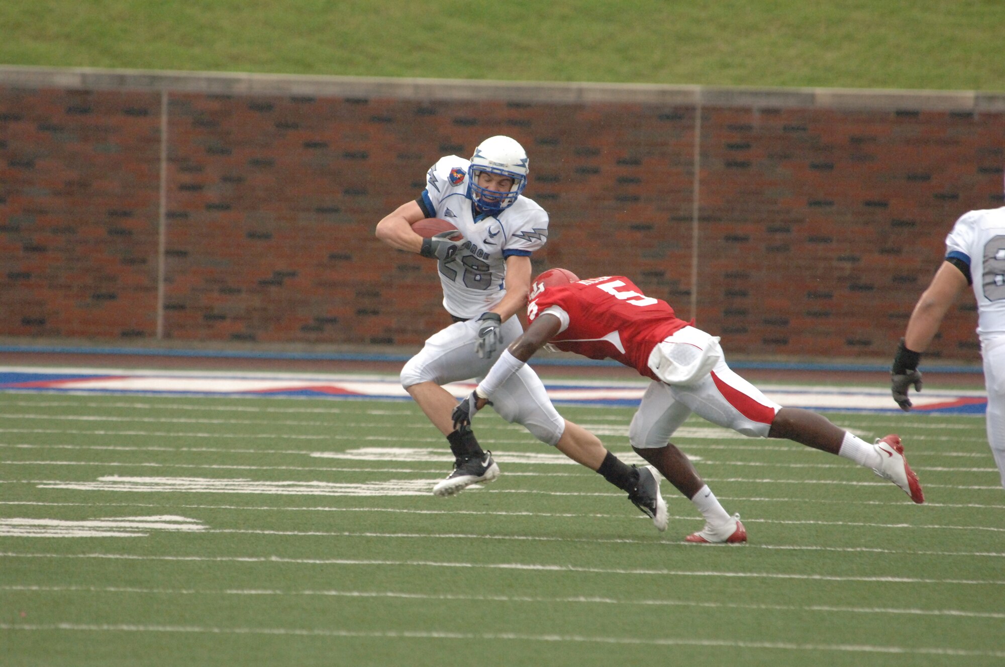 U.S. Air Force Academy receiver Spencer Armstrong works to slip around Houston Cougar safety Ernest Miller to break free for a 55 yard run Sept. 13 in Dallas. Falcon backs ran 71 times for 380 yards to secure a 31-28 win over Houston and advance to 3-0 on the season. (U.S. Air Force photo/John Van Winkle) 

