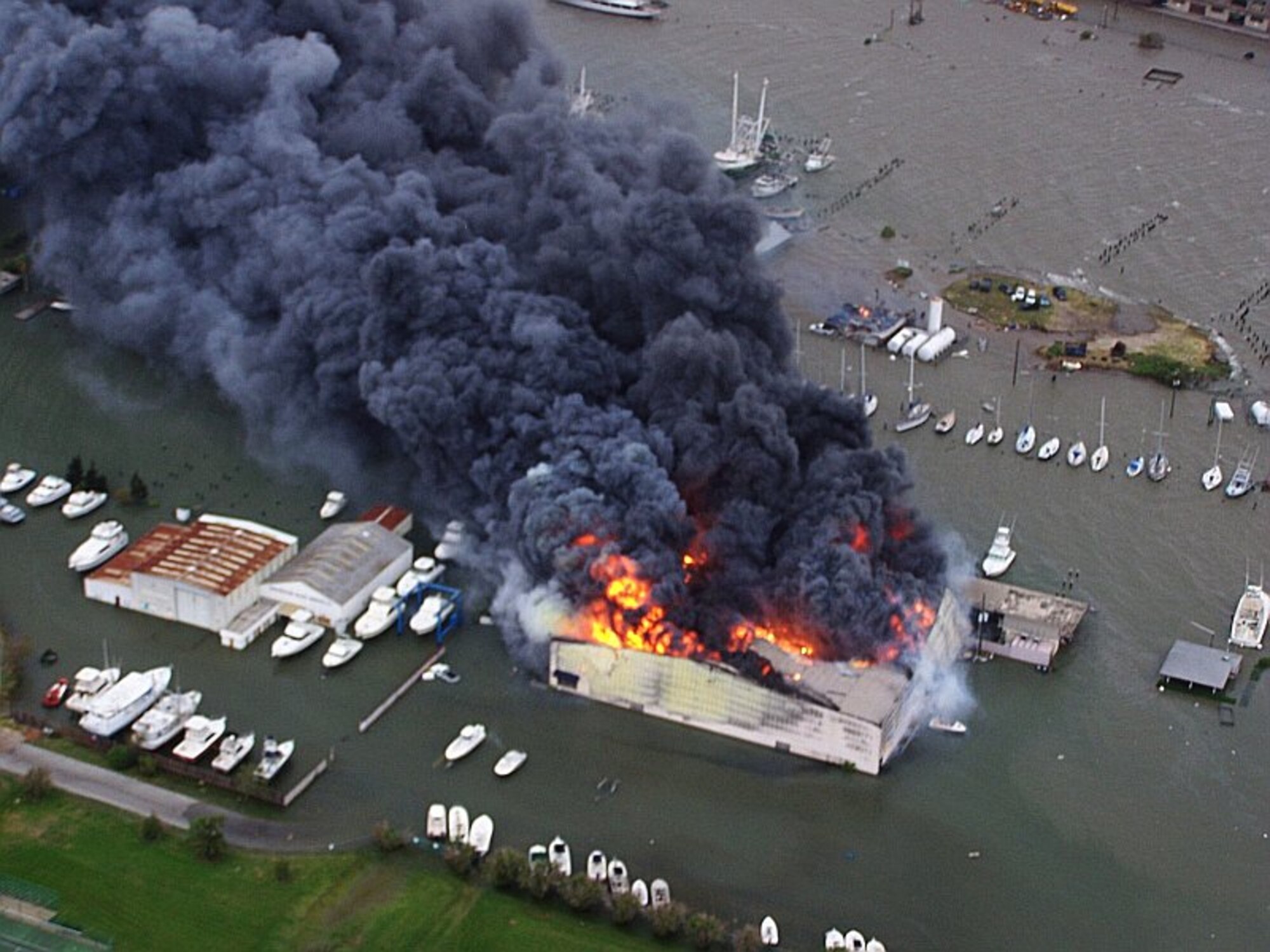 Joint Task Force 129 crew, Jolly 92, flies over a yacht warehouse fire in Galveston, Texas, Sept. 12. The California Air National Guard crew of Jolly 92 rescued six civilians and pets stranded in Galveston. (U.S. Air Force photo by Master Sgt. Wally Bacio)