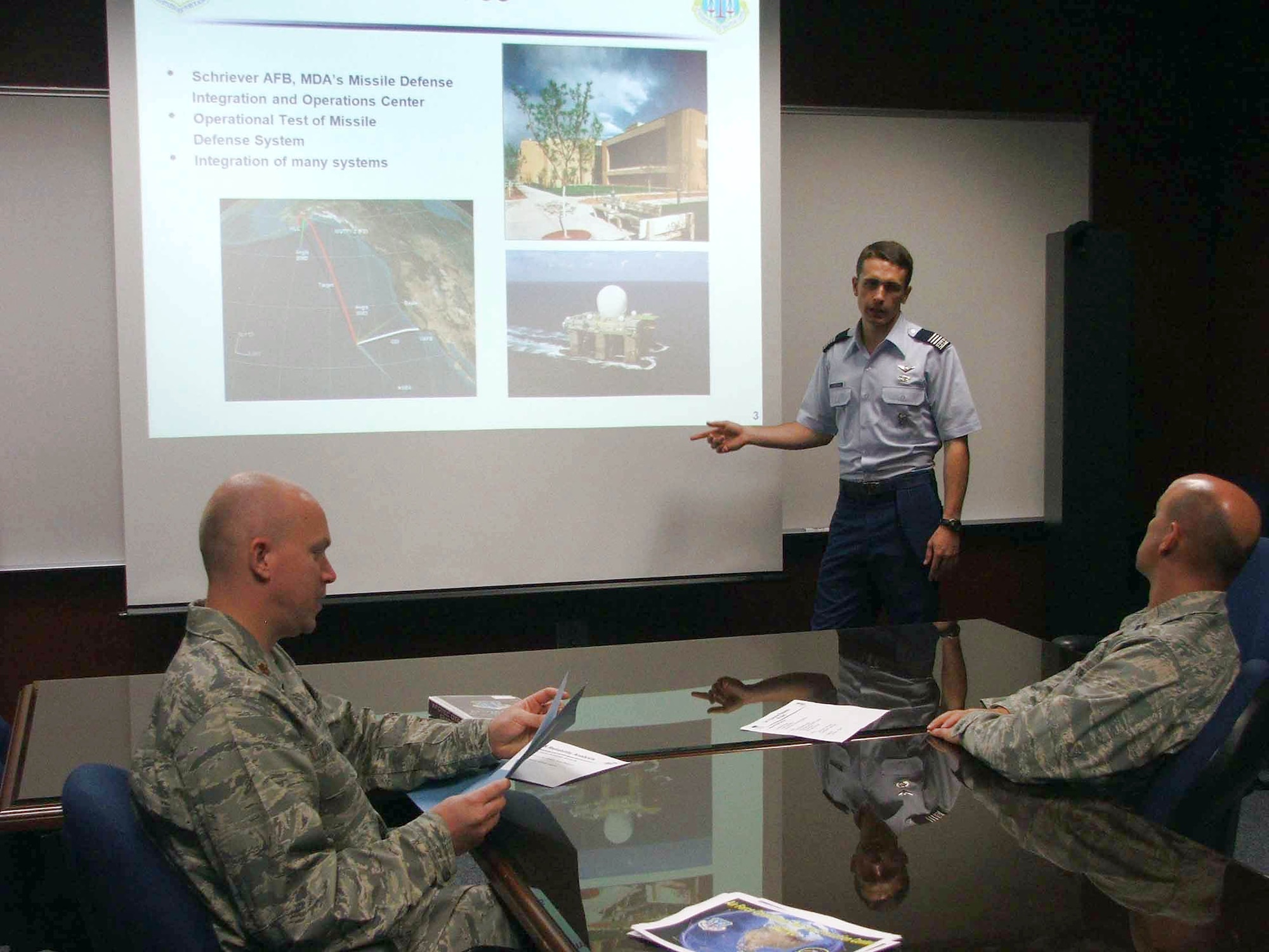 Air Force Academy Cadet First Class Bryan Freeman briefs Maj. Dan Cammack (left) and Capt. Tom Wegner on a recent ballistic missile defense flight test.  Cadet Freeman worked at the Air Force Operational Test and Evaluation Center's Detachment 4 at Peterson Air Force Base, Colo., for five weeks. He was participating in the AFOTEC Mentoring Program that integrates Academy cadets with operational test teams to work on real-world Air Force projects. (U.S. Air Force photo/Katherine Gandara)