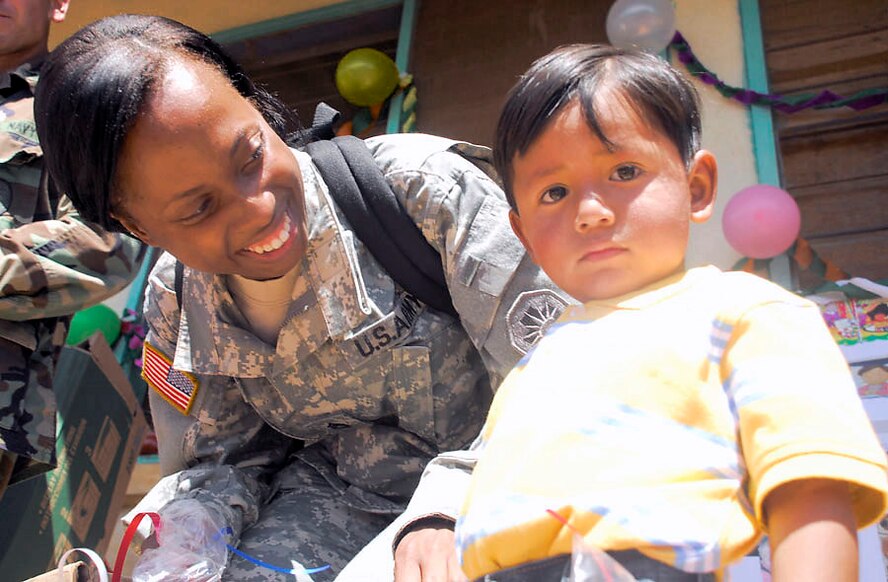 Army Staff Sgt. Jenise Harris spends time with child during Children's Day Sept. 10 in Guajiquiro, Honduras. More than 400 children in two towns spent time with servicemembers from Joint Task Force-Bravo. Sergeant Harris is assigned to JTF-Bravo Civil Affairs. (U.S. Air Force photo/Staff Sgt. Joel Mease)