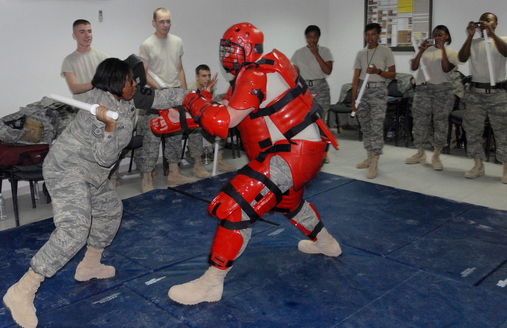 JOINT BASE BALAD, Iraq -- Tech. Sgt. Rosland Upshaw, 332nd Expeditionary Security Forces Squadron, goes on the offensive with a training baton against Tech. Sgt. Zachary Merkl, who wore a RedMan suit to protect himself during a baton training class here Sept. 10. Both Airmen are deployed as part of the largest security forces unit deployed into combat to defend an airbase since the Vietnam War. Upshaw, a native of Statesboro, Ga., is deployed here from Robins Air Force Base, Ga., and Merkl is an Ephrata, Wash., native deployed from Mountain Home Air Force Base, Idaho. (U.S. Air Force photo/Tech. Sgt. Erik Gudmundson)