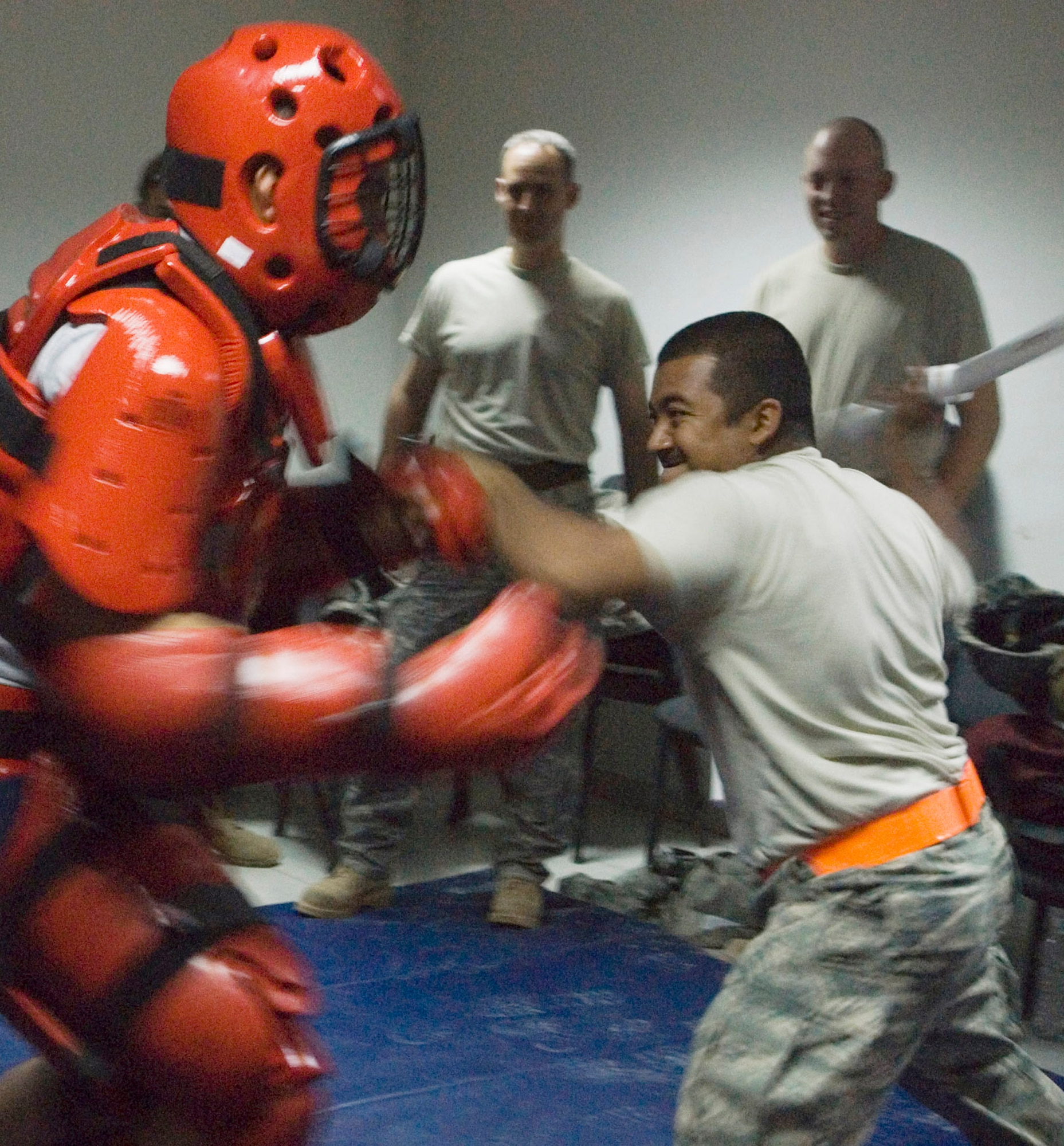 JOINT BASE BALAD, Iraq -- Senior Airman Reginald Orme wears a RedMan suit to protect himself during baton training class while a student, Senior Airman Rigoberto Valerio, holds up his left arm in defense and prepares a crushing blow with a training baton during a training class Sept. 10. Both Airmen are assigned to the 332nd Expeditionary Security Forces Squadron. Both Airmen are deployed as part of the largest security forces unit deployed into combat to defend an airbase since the Vietnam War. Valerio, a native of Corpus Cristi, Texas, is deployed here from Robins Air Force Base, Ga., and Orme is a native of Pomona, Calif., deployed from Beale Air Force Base, Calif. (U.S. Air Force photo/Tech. Sgt. Erik Gudmundson)