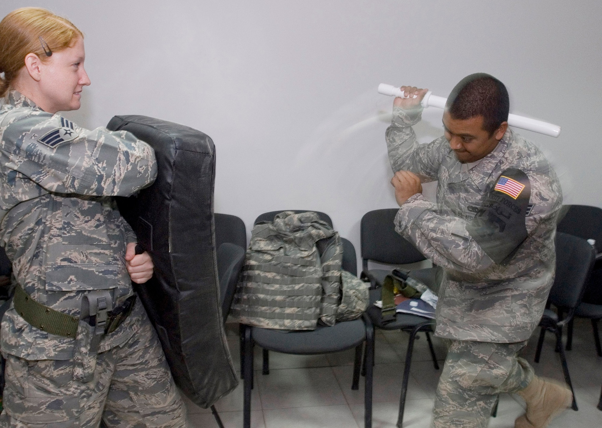 JOINT BASE BALAD, Iraq -- Senior Airman Ashley Swanson, 332nd Expeditionary Security Forces Squadron (left), holds a strike training pad while Senior Airman Rigoberto Valerio, 332nd ESFS, strikes with a training baton during a training class here Sept. 10. Both Airmen are deployed here from Robins Air Force Base, Ga. as part of the largest security forces unit deployed into combat to defend an airbase since the Vietnam War. Swanson is a native of Eagan, Minn. and Valerio's hometown is Corpus Cristi, Texas. (U.S. Air Force photo/Tech. Sgt. Erik Gudmundson)