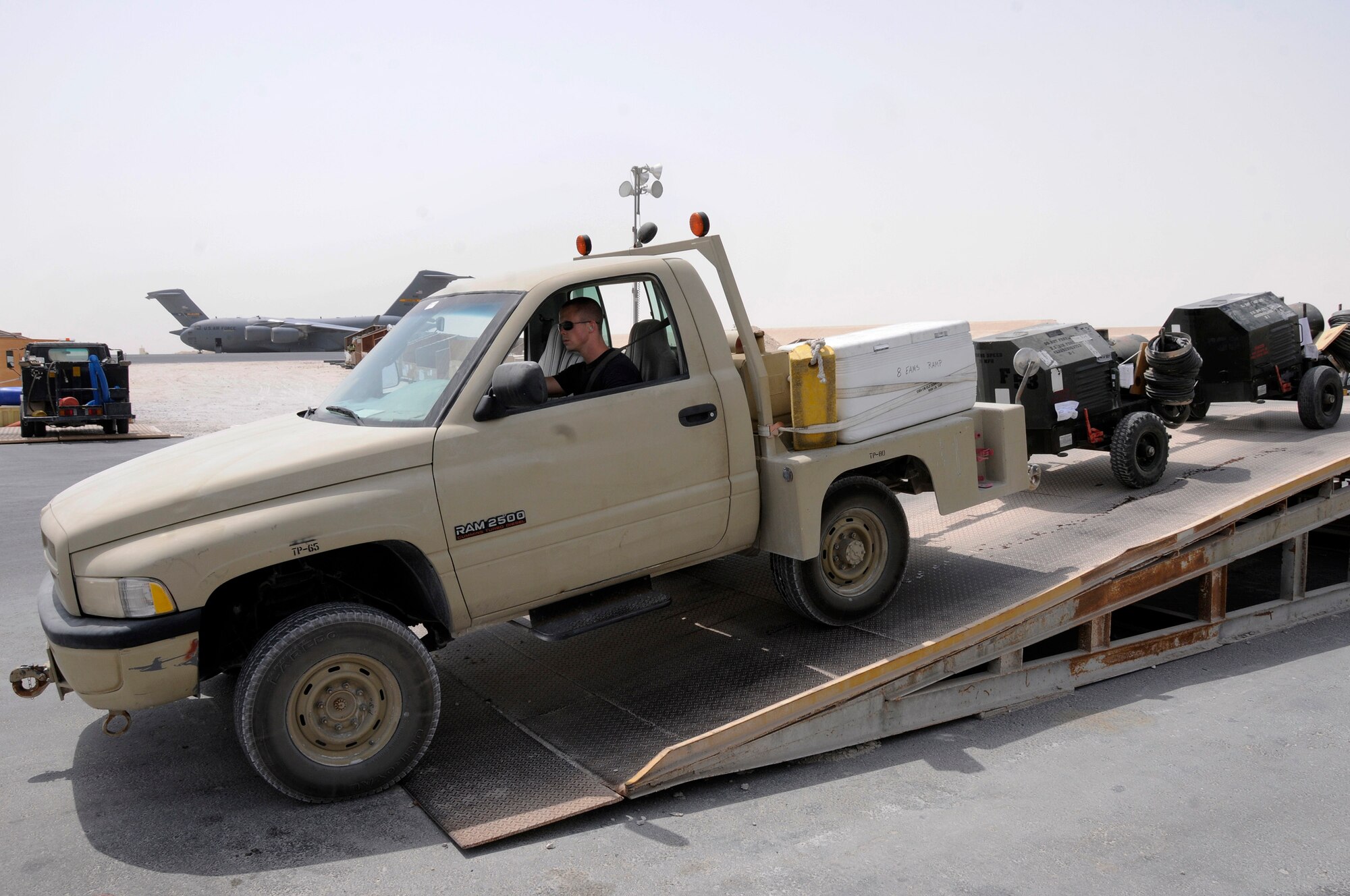 Senior Airman Zachary Weekly, 8th Expeditionary Air Mobility Squadron (8 EAMS), drives the bobcat pulling tandem connected rolling stock off the 60K loader Sept. 12, 2008.  The rolling stock was off loaded onto the 60k loader from a C-17 and the items will be used here at this undisclosed location in Southwest Asia or put onto other aircraft for movement onward into the theater of operations.   Airman Weekly is a native of Delanson, N.Y.., and is deployed here from the Stratton Air National Guard, Schenectady, N.Y., in support of Operations Iraqi and Enduring Freedom and Joint Task Force-Horn of Africa.  (U.S. Air Force photo by Tech. Sgt. Michael Boquette/Released)