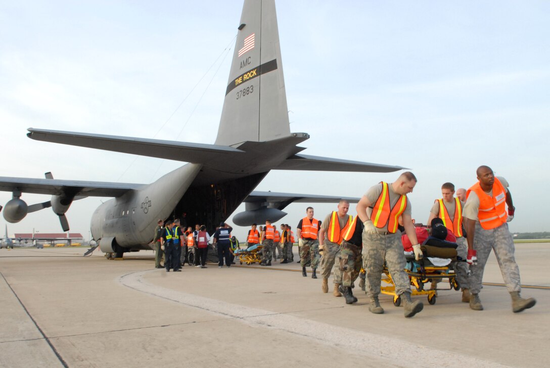 U.S. Air Force Airmen from the 37th and 59th Air Wing unload hospital patients evacuating from Beaumont, Texas, September 12, 2008, in advance of Hurricane Ike making landfall. C-130 Hercules from Little Rock Air Force Base, with aeromedical evacuation crews from the 908th Aeromedical Evacuation Squadron, Scott AFB, helped move vulnerable patients out of the storm’s path while maintaining a high level of care during transport. The C-130 is distinct from similar platforms due to its ability to perform diverse roles, including airlift support, aeromedical evacuation missions, and disaster relief missions. (U.S. Air Force photo by Staff Sgt. Chris Willis)