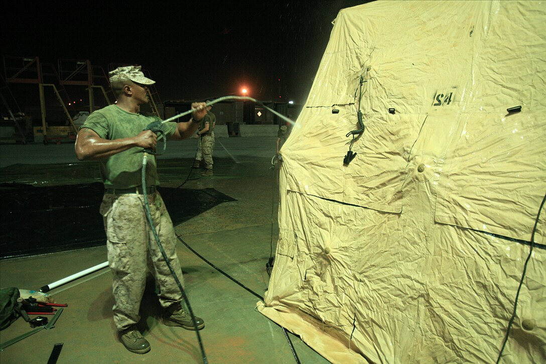 Sgt. Wilfort Edmonds, motor transport maintenance chief with the 15th Marine Expeditionary Unit, uses a pressure sprayer to clean dirt and debrit from a high mobility multipurpose vehicle.::r::::n::The 15th MEU's vehicles and equipment were required to meet the US Central Command's customs and agricultural standards before being re-embarked aboard ships prior to returning to the Continental United States.(Official USMC photo by Staff Sgt. TG Kessler)(Released)