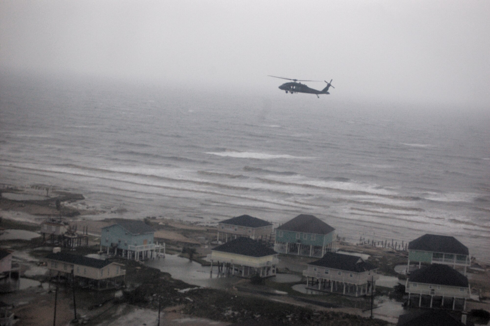 Airmen aboard an HH-60G Pave Hawk fly with another HH-60G to survey the damage caused by Hurricane Ike Sept. 13 around Galveston, Texas. Airmen from across the Air Force are deployed to the 331st Air Expeditionary Group at Randolph Air Force Base, Texas, to assist with rescue missions. Three HH-60Gs and two HC-130 Hercules aircraft from the 331st AEG flew over the devastated area to assist with relief operations. (U.S. Air Force photo/Staff Sgt. Corey Parrish) 

