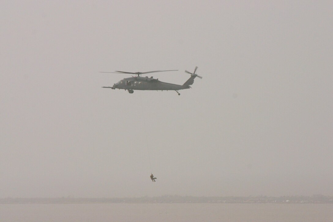 A Joint Task Force 129 pararescueman hoists a hurricane victim in to the hovering HH-60G Pave Hawk helicopter Sept. 13 near Galveston, Texas. The JTF 129 crews rescued 48 people and pets stranded in the Galveston area. (U.S. Air Force photo/Tech. Sgt. Brock Woodward)