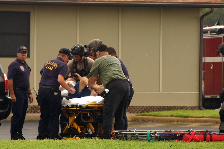 Joint Task Force 129 pararescuemen transfer a rescued hurricane victim to Texas firefighters Sept. 13 near Galveston, Texas. The JTF 129 crews rescued 48 people and pets stranded in the Galveston area. (U.S. Air Force photo/Tech. Sgt. Brock Woodward)  