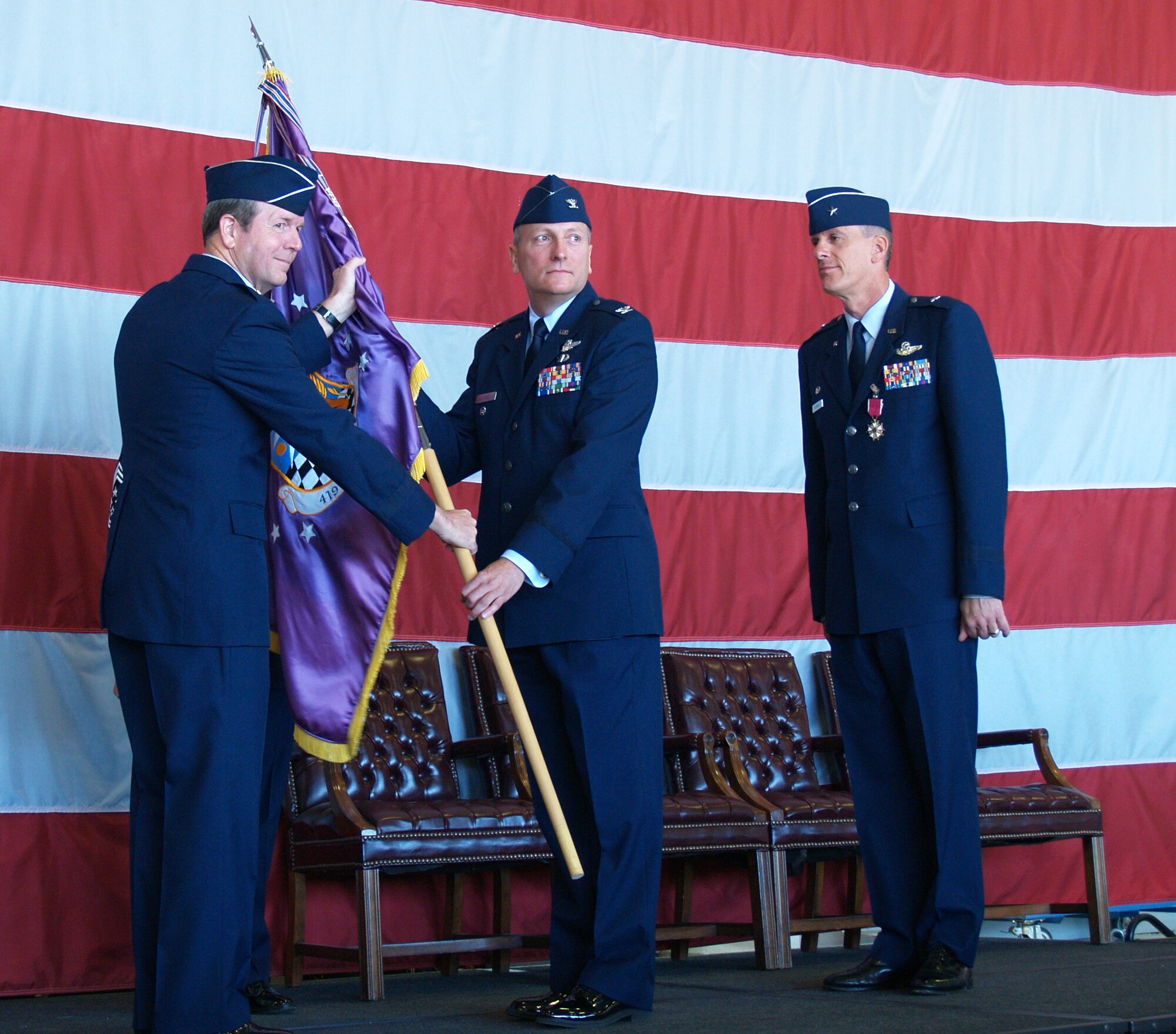 Col. Walter J. Sams receives the wing flag of the 419th Fighter Wing from Brig. Gen.  Thomas R. Coon, commander of the 10th Air Force, symbolically taking the reins of leadership of the wing, as part of a change of command ceremony during the September unit training assembly.  Departing commander Brig. Gen. Gary M. Batinich stands at right. (U.S. Air Force Photo/Senior Airman Brandon Craig)