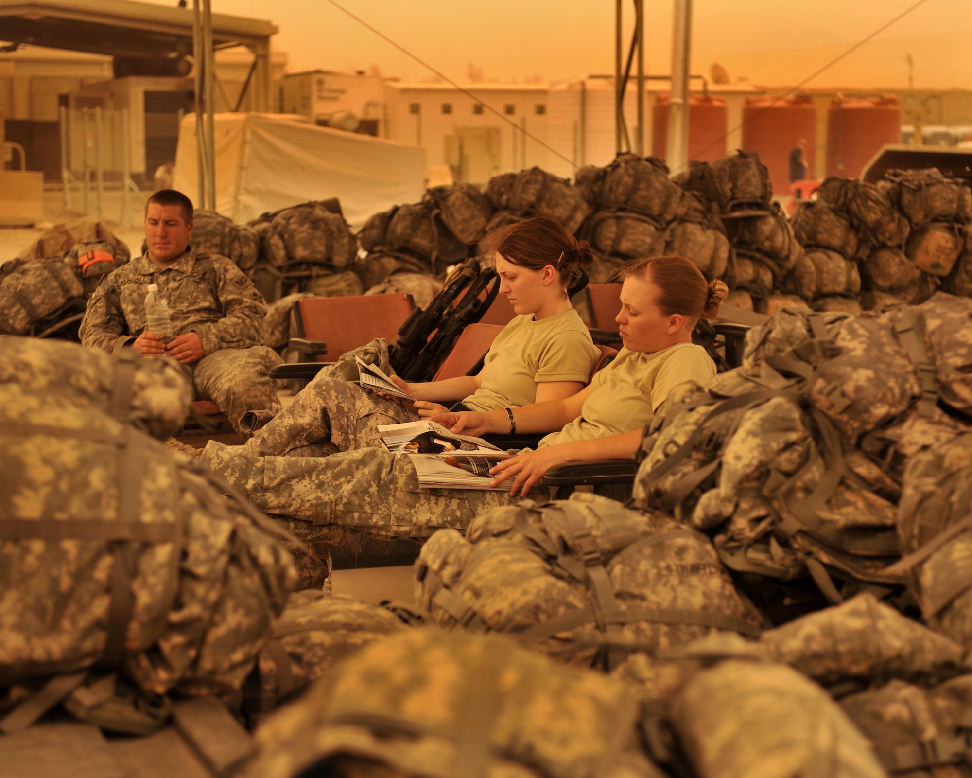 9/14/2008 ? SATHER AIR BASE, Iraq ? Soldiers headed to a forward operating base guard unit member?s luggage as they wait for a dust storm to lift at Sather Air Base, on the west side of Baghdad International Airport. Aircraft were grounded throughout the day as the dust brought visibility down to less than 1,000 meters. The Soldiers are deployed from Fort Carson, Colo., to the 2nd Brigade, 4th Infantry Division. Pictured from right to left are Spc. Kelly DeGreek, Spc. Lindsey Rush and Spc. Jesse Kendall. (U.S. Air Force photo by Master Sgt. Brian Davidson)