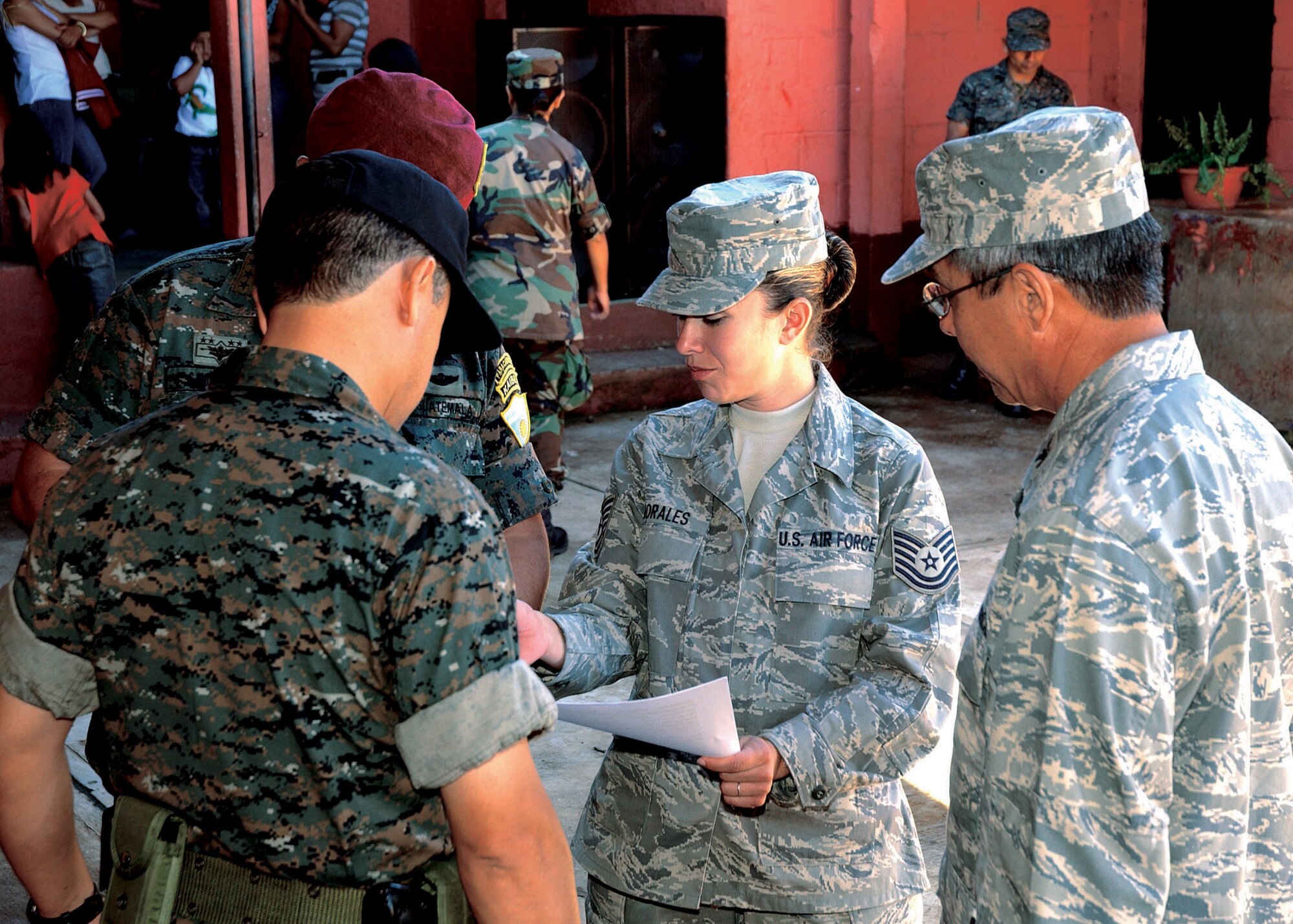Tech. Sgt. Shirley Morales, serving as a translator, reviews a script with U.S. and Guatemalan military members prior to an opening ceremony welcoming the 163rd Medical Group to Santa Rosa, Guatemala, to provide medical care to the local citizens. Sergeant Morales, who was born and raised in Santa Rosa, accompanied medical group during the recent medical readiness training exercise to assist with translating for the team.  Sergeant Morales is a force development technician with the 163rd Reconnaissance Wing.  (U.S. Air Force photo)