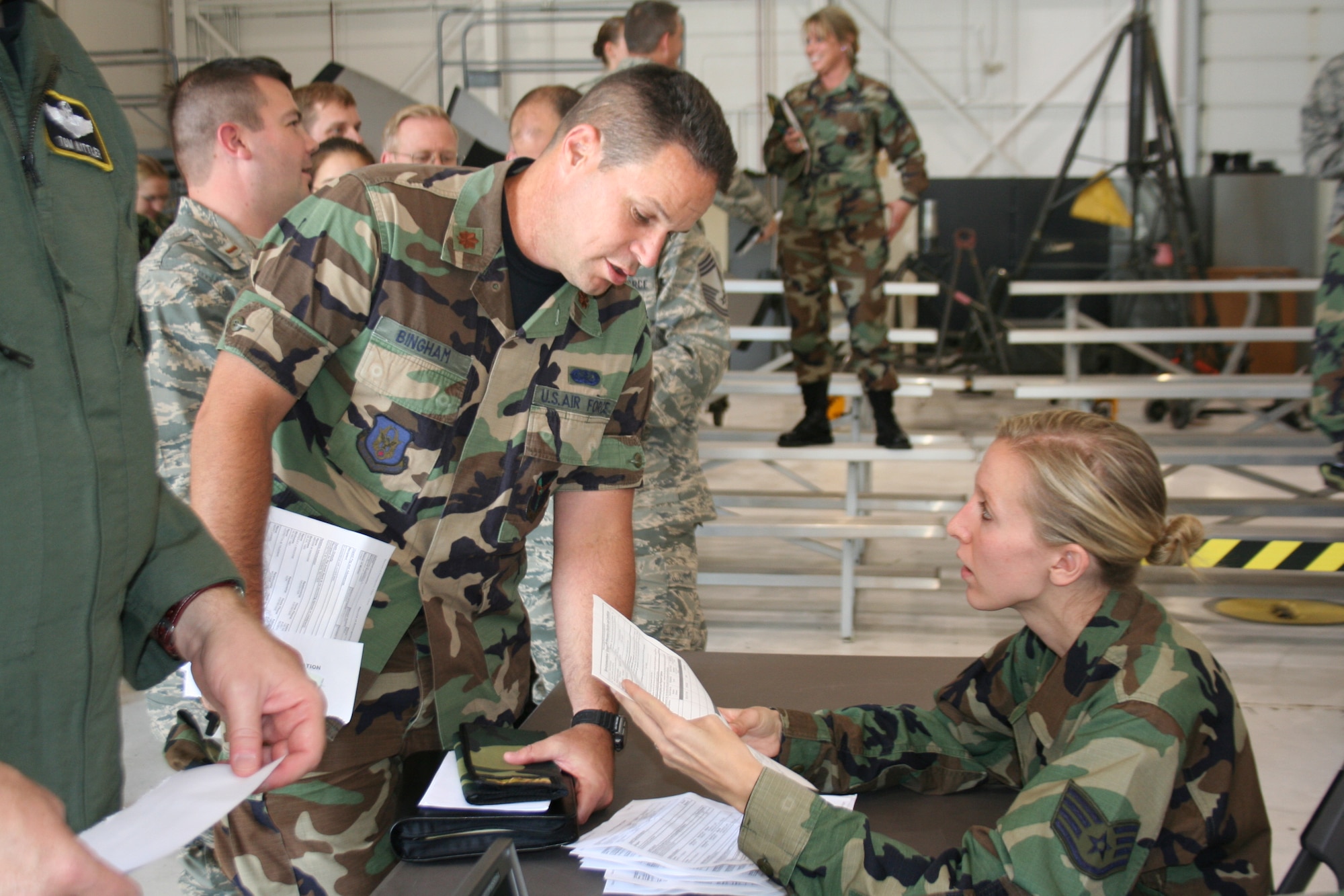 Maj. Lowell Bingham, Executive Officer for  the  Mission Support Group, reviews his mobility paperwork with Staff Sgt. Kristen Rhodes, a personnel specialist with the 911th Military Personnel Flight, Aug. 9, in Hangar 129.  (U.S. Air Force Reserve photo/ Senior Airman Tammy Cario)