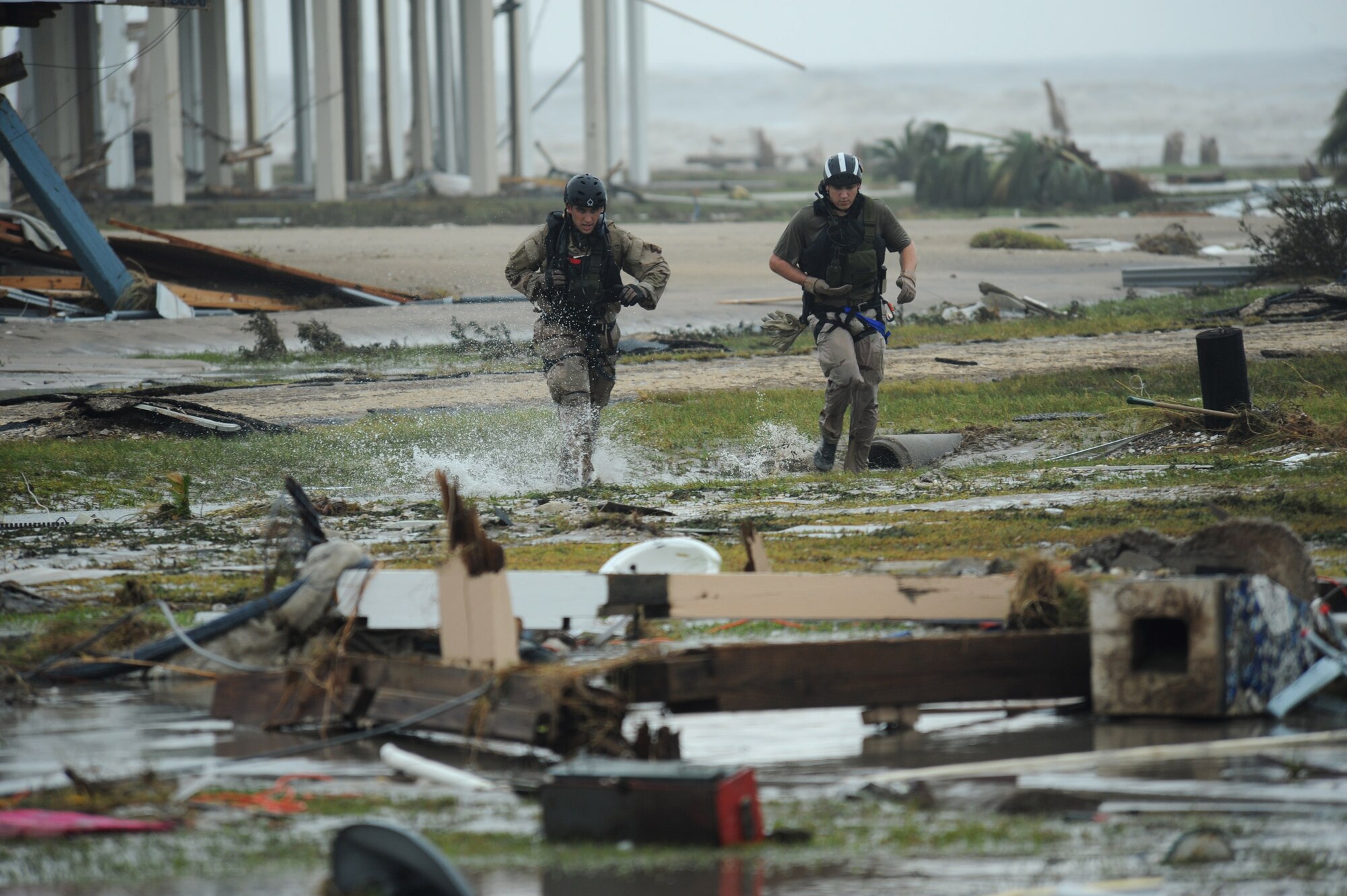 Staff Sgt. Lopaka Mounts (left) and Senior Airman Brandon Smith run through a flooded portion of Galveston, Texas, searching for residents needing help during search and rescue operations after Hurricane Ike, Sept. 13. Sergeant Mounts and Airman Smith are both pararescueman assigned to the 331st Air Expeditionary Group at Randolph Air Force Base, Texas. (U.S. Air Force photo/Staff Sgt. James L. Harper Jr.)