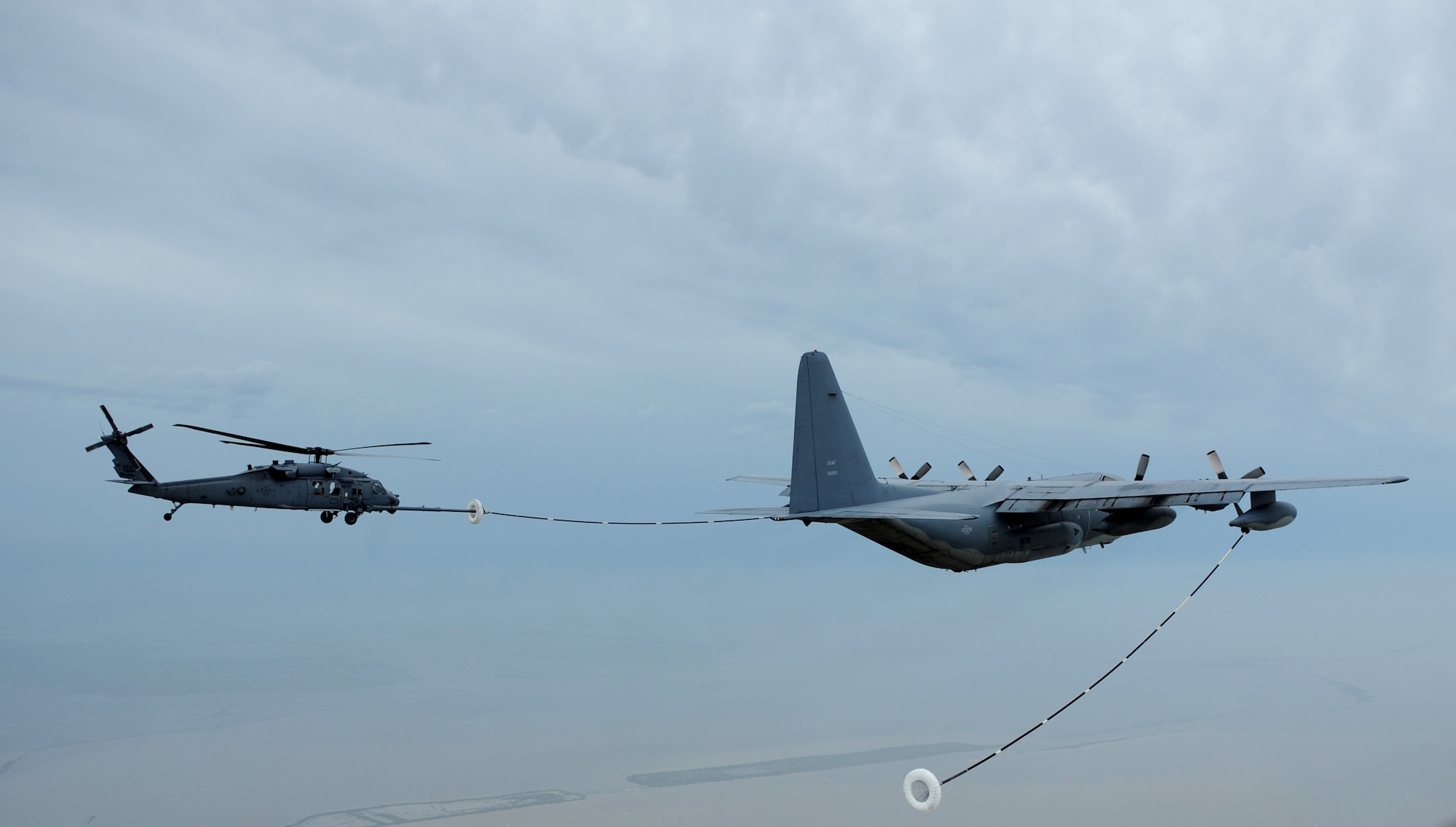 An HH-60 Pave Hawk receives fuel from a HC-130 Hercules during search and rescue operations in Galveston, Texas, after Hurricane Ike, Sept. 13. Both aircraft are assigned to the 331st Air Expeditionary Group at Randolph Air Force Base, Texas. (U.S. Air Force photo/Staff Sgt. James L. Harper Jr.)
