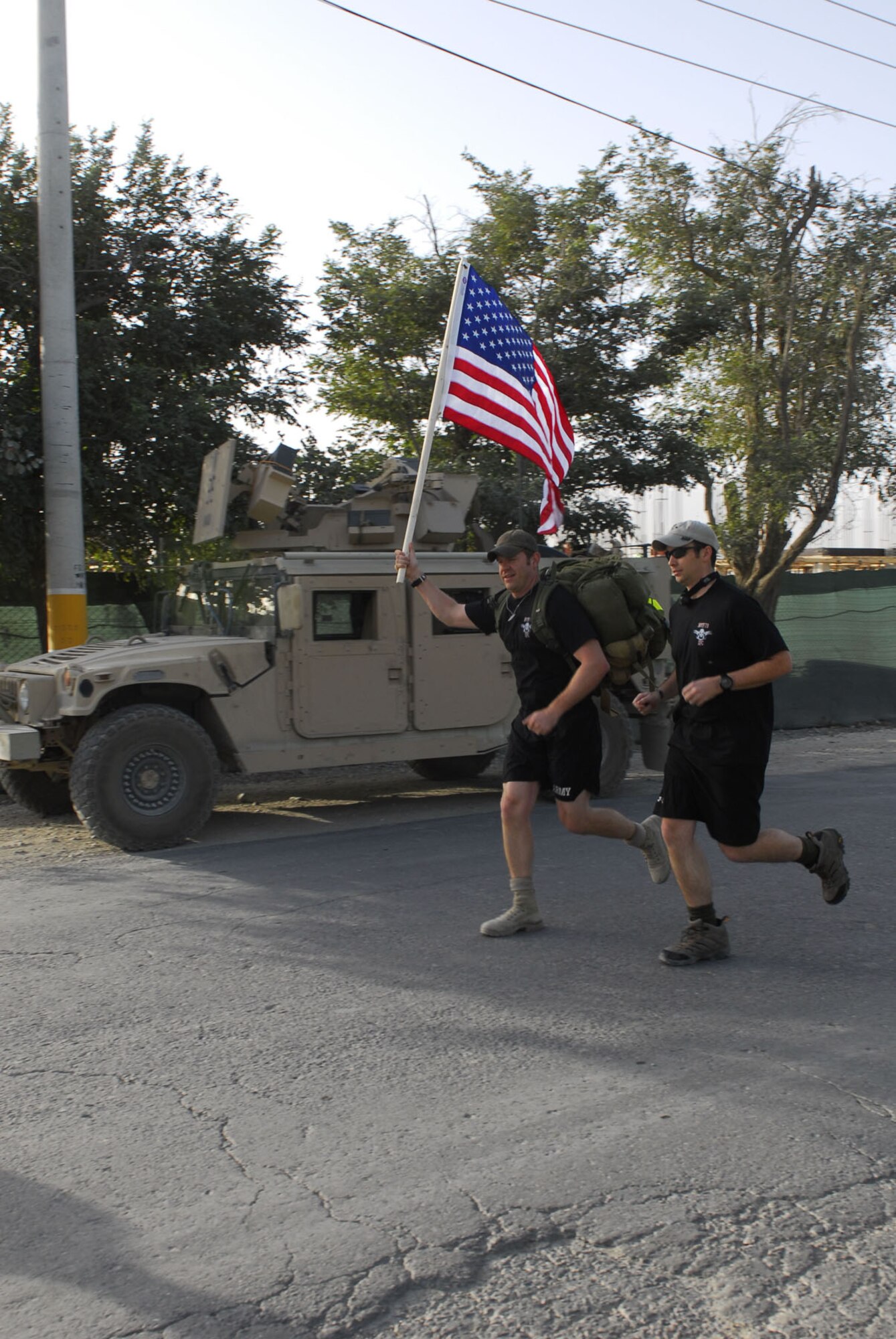 A Special Operations Task Force-73 Soldier proudly displays the American flag as he finishes an eight-mile Bagram Airfield perimeter run held Sept. 6 in honor of three fallen SOTF-73 warriors. (Courtesy photo)