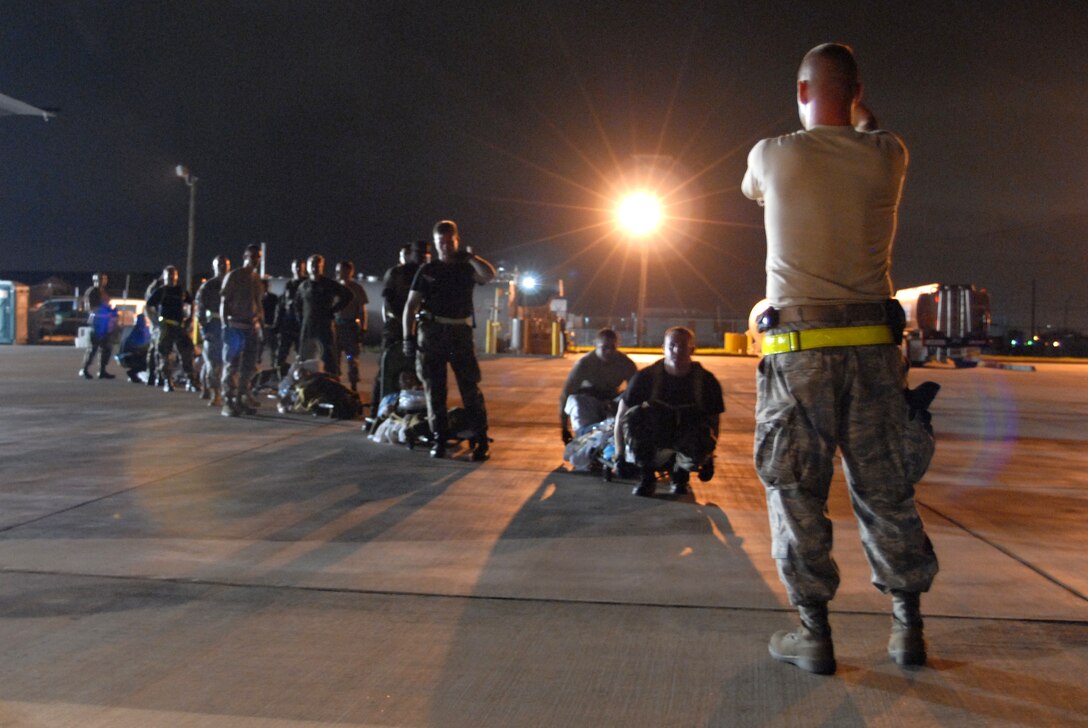 U.S. Air Force airmen wait to load patients onto a C-130E aircraft at Corpus Christi International Airport in Texas, Sept. 11, 2008, during an evacuation prior to Hurricane Ike. U.S. Air Force C-130 aircraft and crews are tasked routinely to evacuate possible natural disaster victims to safer locations. 