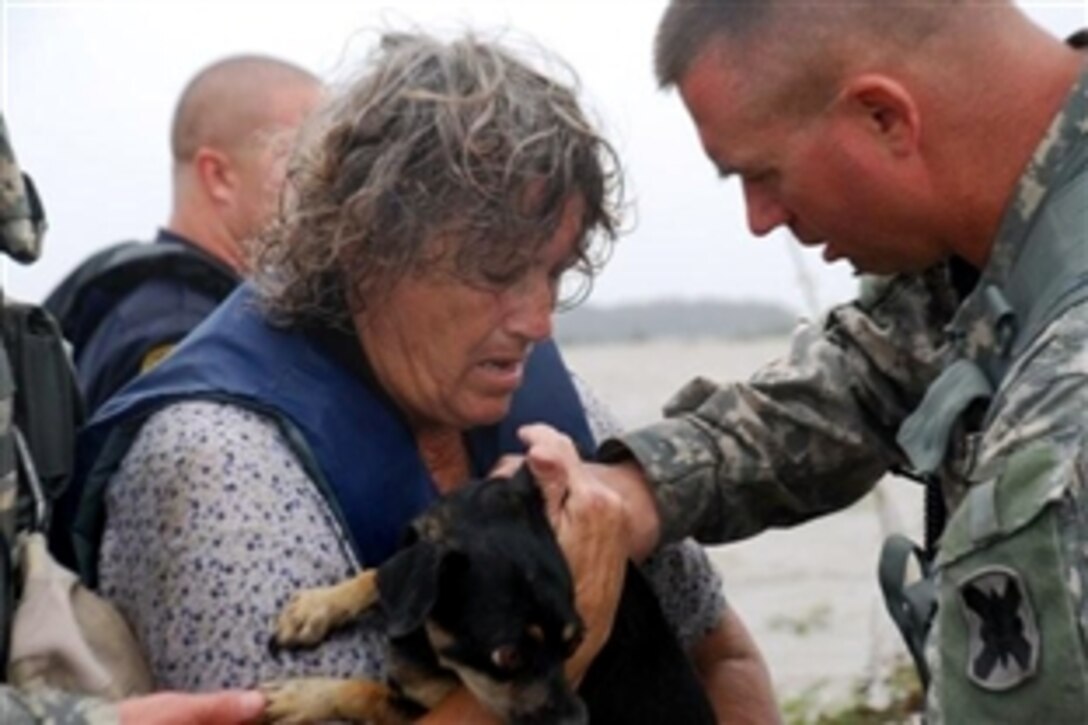 Army Command Sgt. Maj. Ken Wagner, of the Louisiana National Guard's 256th Infantry Brigade Combat Team, helps Mary Louise Fowler with her puppy, Peanut, during an evacuation near Hackberry, La., Sept. 13, 2008. Mary and her husband were rescued by local police from their boat after escaping from their home in the wake of flooding caused by Hurricane Ike. National Guard troops are supporting hurricane relief efforts.