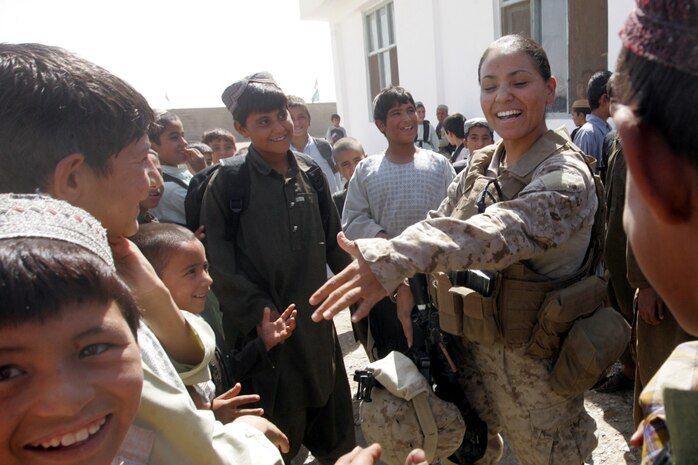 Civil Affairs Marine Cpl. Ericka L. Garcia meets Afghan kids at the reopening of a boys’ school in Delaram, Afghanistan, Sept. 14. (U.S. Marine Corps photo by Sgt. Ray Lewis)