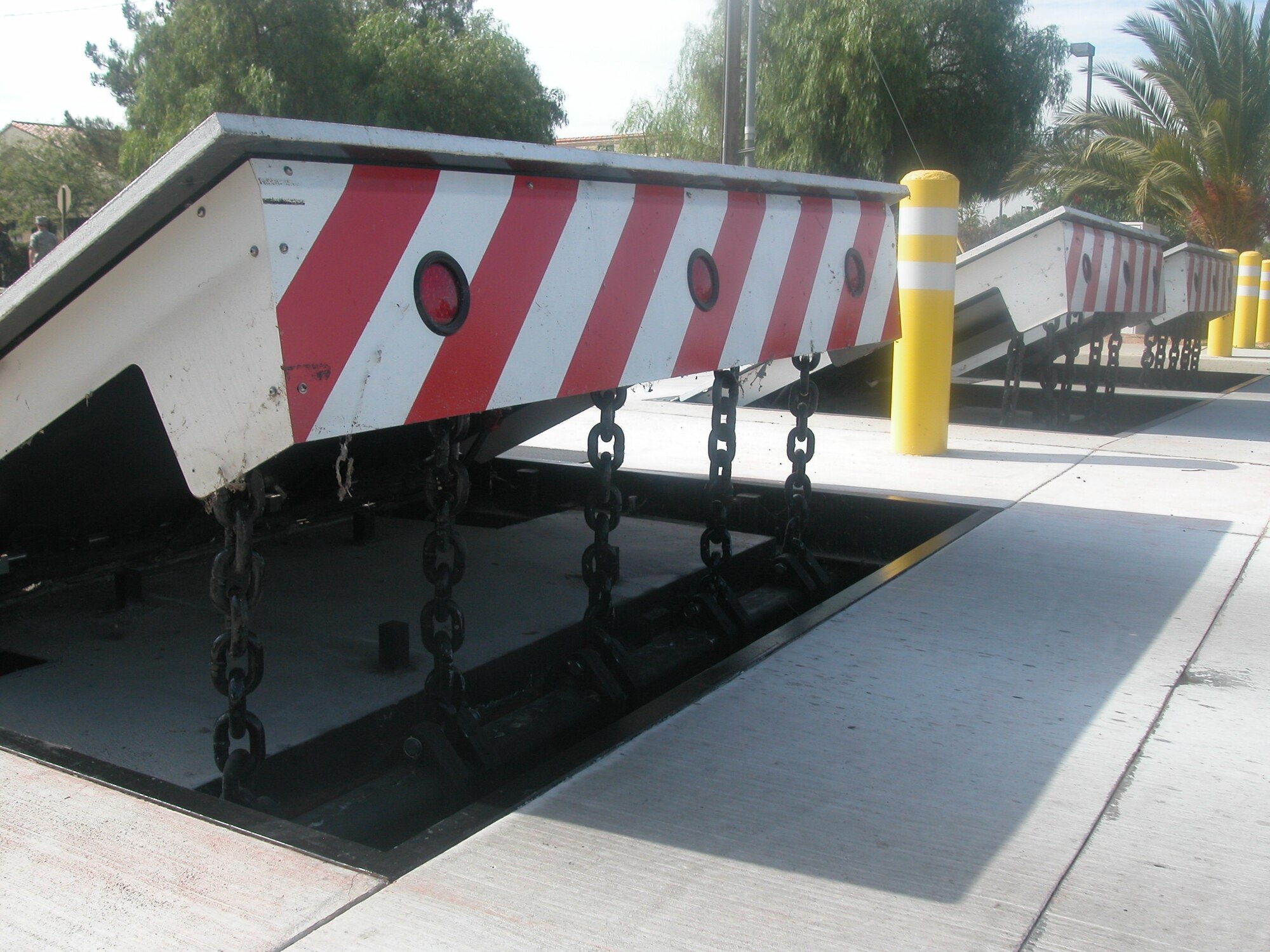 The  photo shows the barriers in the fully raised position at about 39 inches high. When the barriers are lowered, the ramps are flushwith the road. The barriers are raised and lowered by hydraulic cylinders.  (U.S. Air Force photo by Will Alexander, 452 AMW/PA)