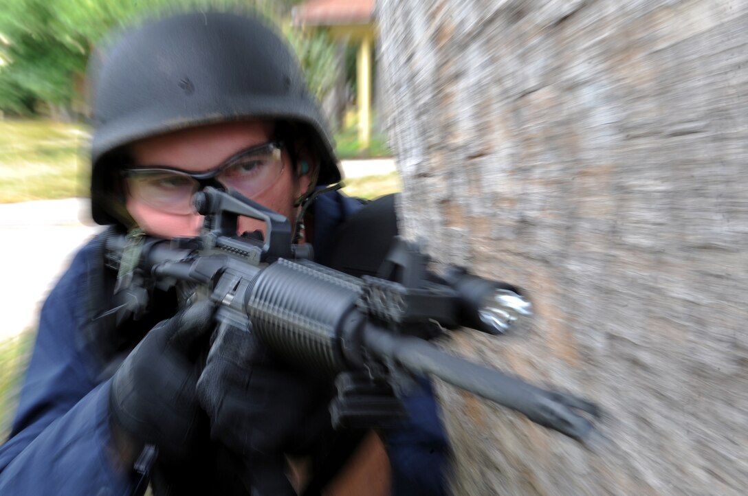 Jeremy Wellnitz, Codington County Sheriff’s Office deputy sheriff, takes position behind a tree, offering parameter security around a house during an exercise on Sept. 12. The scenario involved a high-risk potential suicide. (U.S. Air Force photo/Senior Airman Marc I. Lane)