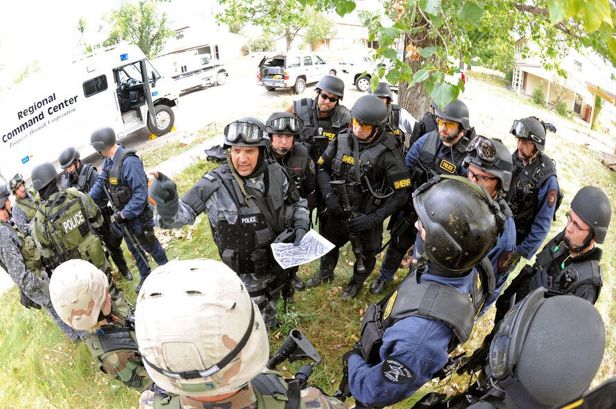 Ray Klinger, Pierre Police Department police officer, uses a map to outline his plan for approaching a suspect’s house during an exercise on S.D., Sept. 12. Officer Klinger was the team leader in a scenario targeted at saving a potential suicide victim. (U.S. Air Force photo/Senior Airman Marc I. Lane)